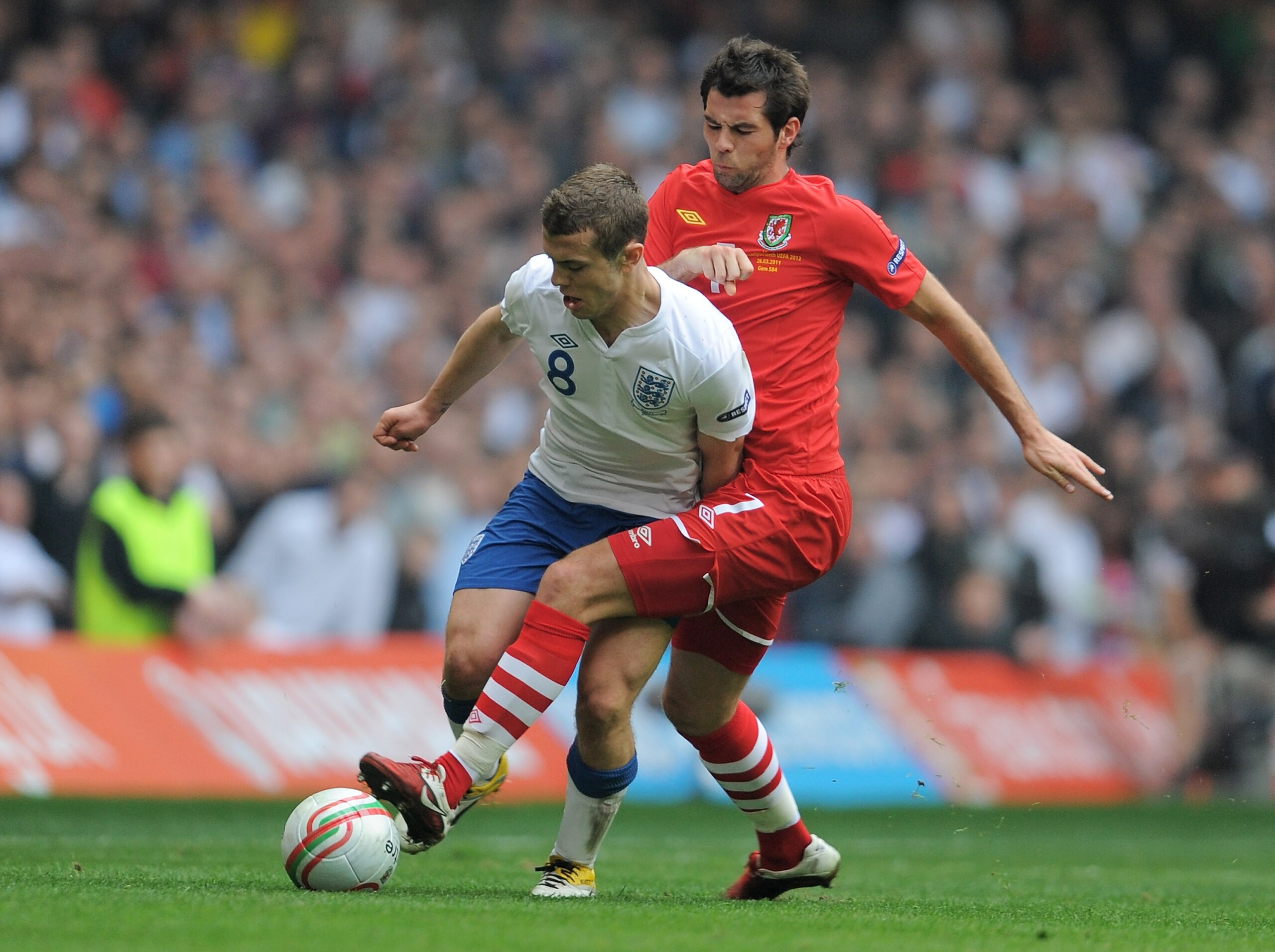 CARDIFF, WALES - MARCH 26: Jack Wilshere of England is challenged by Joe Ledley of Wales during the UEFA EURO 2012 Group G qualifying match between Wales and England at the Millennium Stadium on March 26, 2011 in Cardiff, Wales.  (Photo by Michael Regan/G