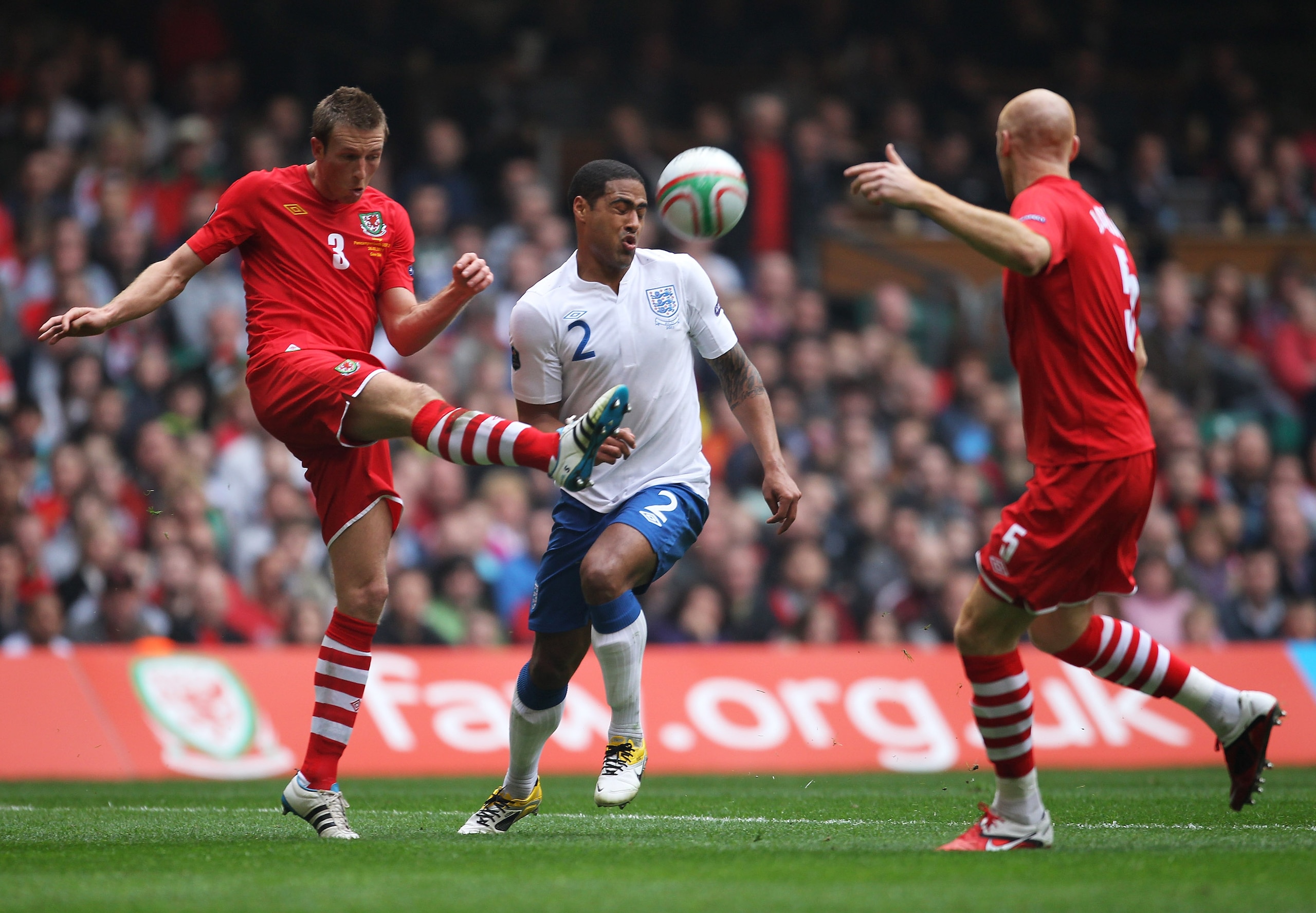 CARDIFF, WALES - MARCH 26: Danny Collins of Wales clears from Glen Johnson of England during the UEFA EURO 2012 Group G qualifying match between Wales and England at the Millennium Stadium on March 26, 2011 in Cardiff, Wales.  (Photo by Alex Livesey/Getty