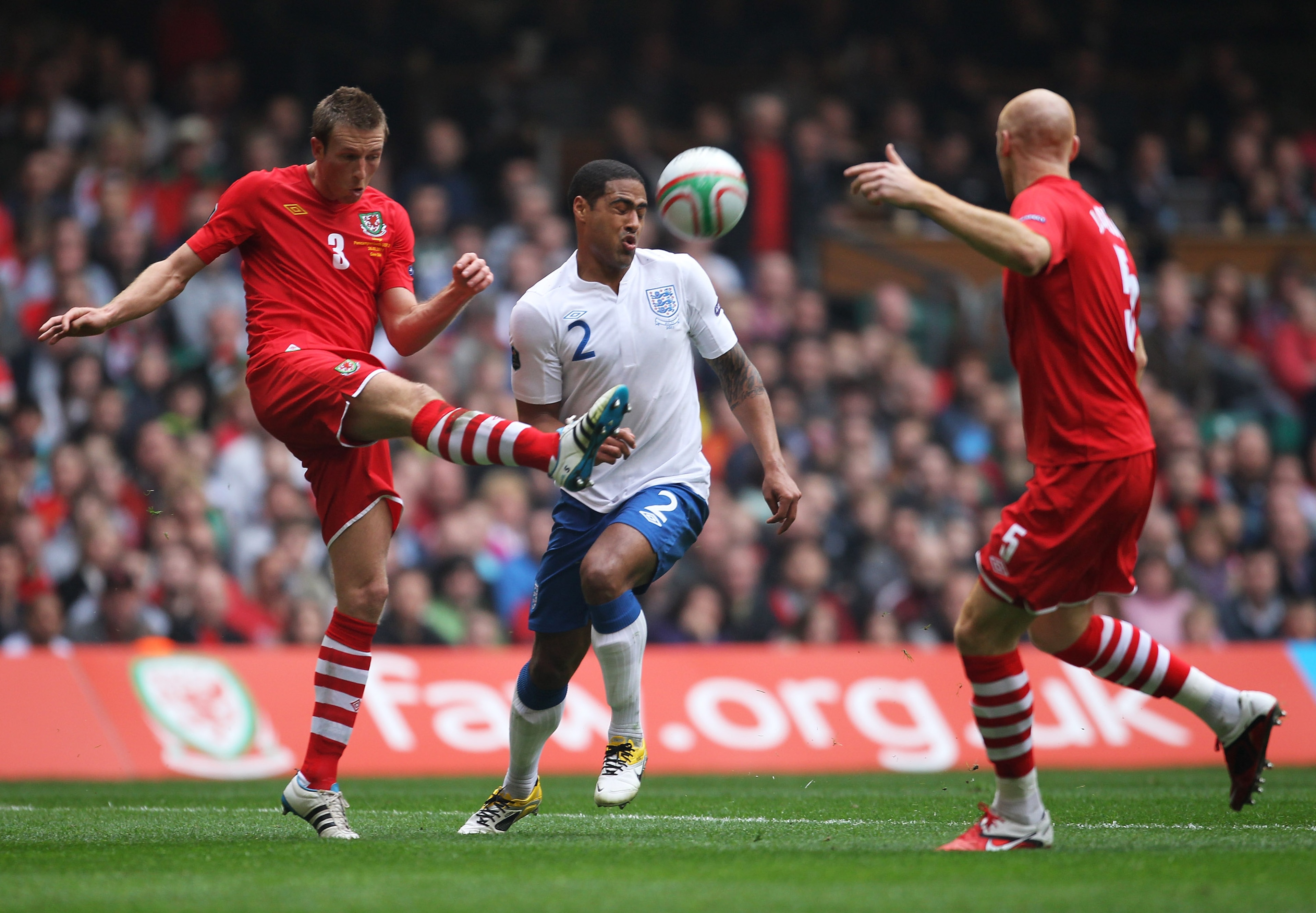 CARDIFF, WALES - MARCH 26: Danny Collins of Wales clears from Glen Johnson of England during the UEFA EURO 2012 Group G qualifying match between Wales and England at the Millennium Stadium on March 26, 2011 in Cardiff, Wales.  (Photo by Alex Livesey/Getty
