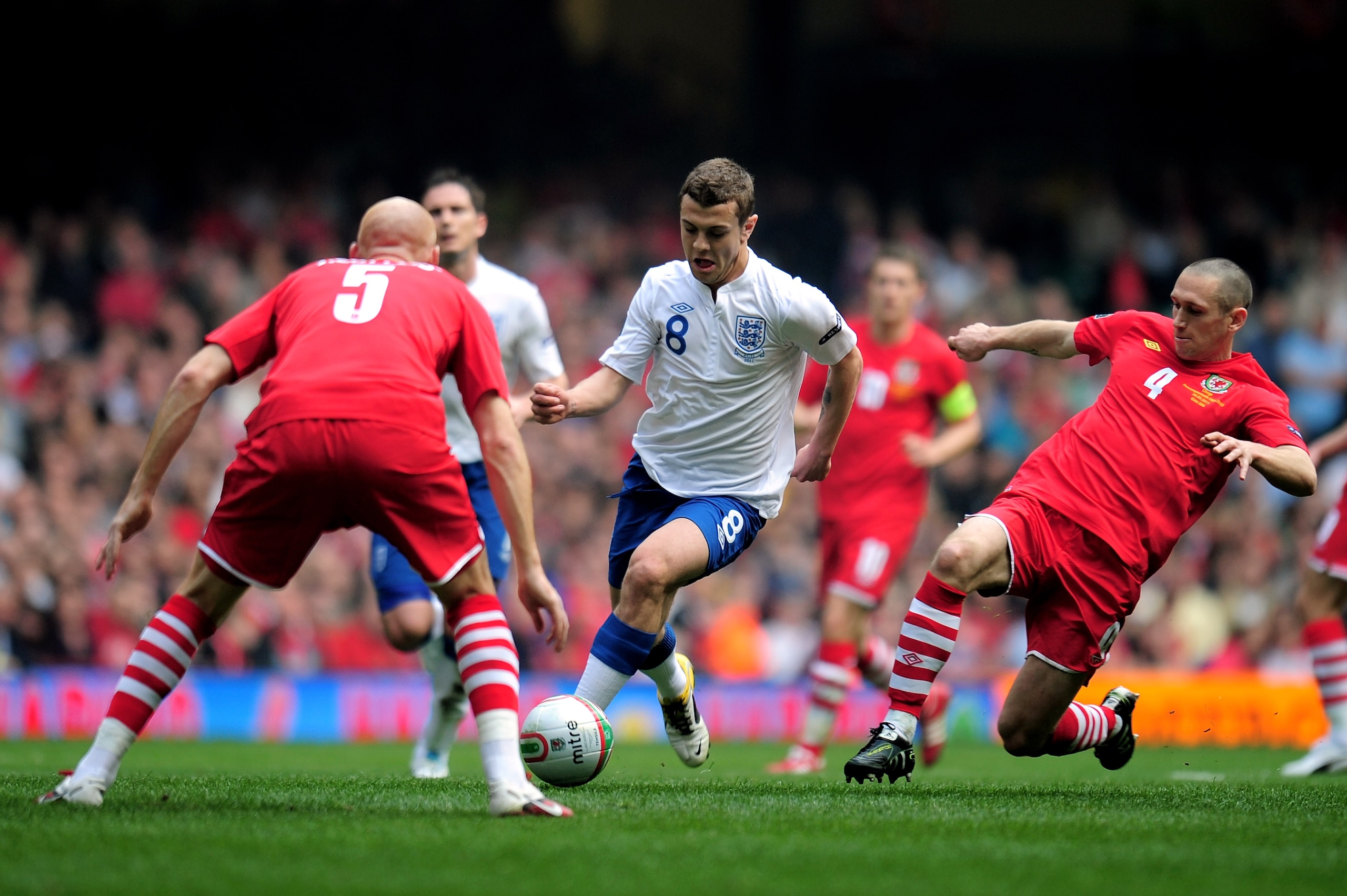 CARDIFF, WALES - MARCH 26:  Jack Wilshere of England is closed down by James Collins #5 and Andrew Crofts #4 of Wales during the UEFA EURO 2012 Group G qualifying match between Wales and England at the Millennium Stadium on March 26, 2011 in Cardiff, Wale
