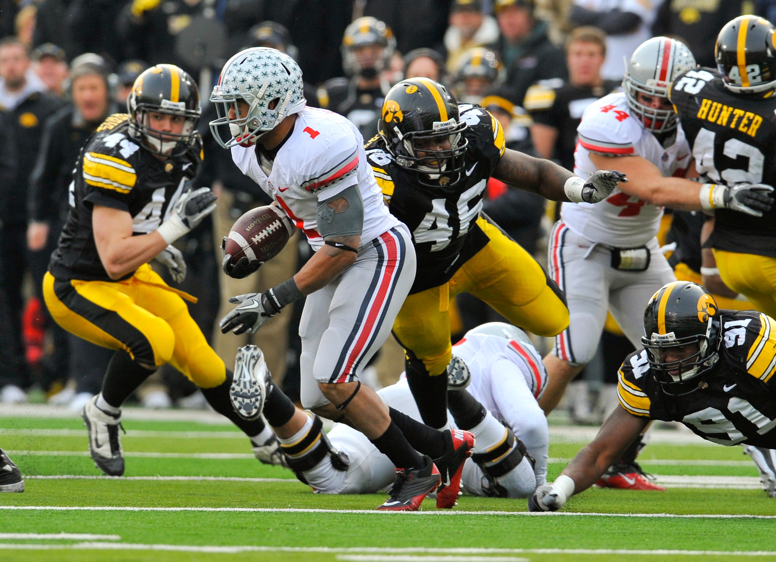 IOWA CITY, IA - NOVEMBER 20:  Tailback Dan Herron #1 of the Ohio State Buckeyes scrambles for yards past defensive end Christian Ballard $46 of the University of Iowa Hawkeyes during the second half of play at Kinnick Stadium on November 20, 2010 in Iowa