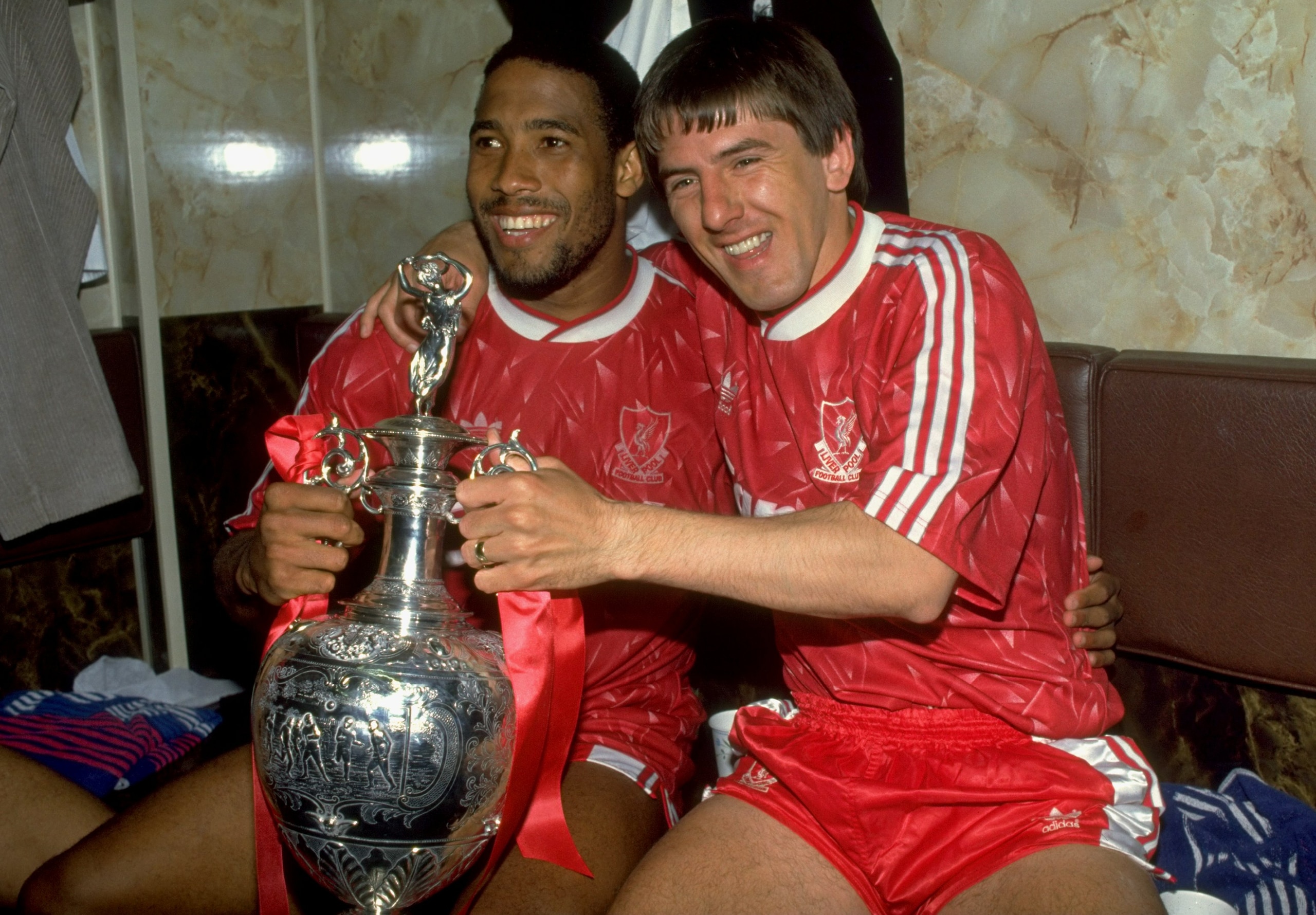 1 May 1990: John Barnes and Peter Beardsley of Liverpool celebrate with the trophy after the Barclays League Division One match against Derby County at Anfield in Liverpool, England. Liverpool won the match 1-0 and became league champions. \ Mandatory Cr 1 May 1990: John Barnes and Peter Beardsley of Liverpool celebrate with the trophy after the Barclays League Division One match against Derby County at Anfield in Liverpool, England. Liverpool won the match 1-0 and became league champions. \ Mandatory Cr