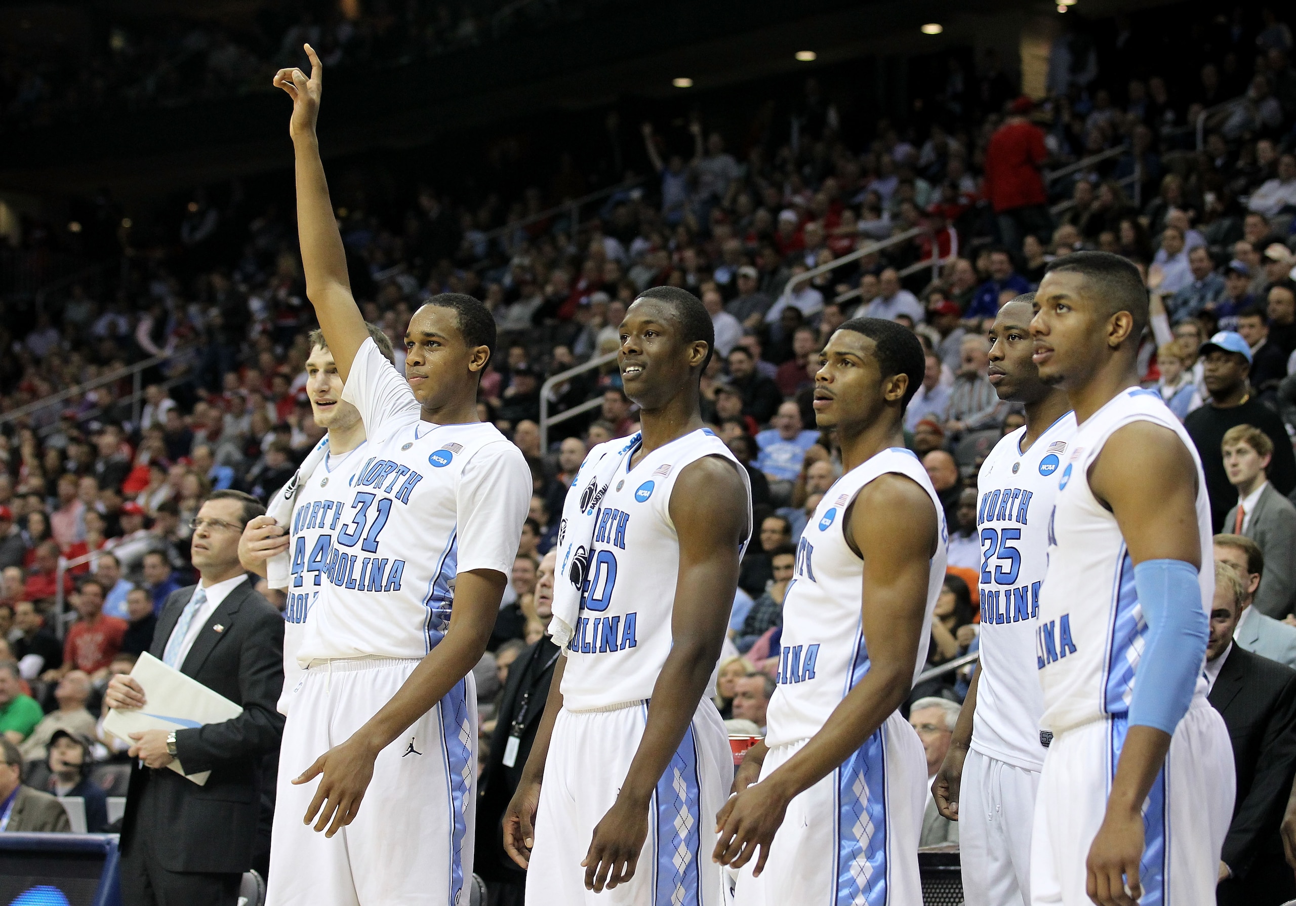NEWARK, NJ - MARCH 25: John Henson #31 of the North Carolina Tar Heels points to the sky on bench to celebrate the defeat of the Marquette Golden Eagles during the east regional semifinal of the 2011 NCAA Men's Basketball Tournament at the Prudential Cen NEWARK, NJ - MARCH 25: John Henson #31 of the North Carolina Tar Heels points to the sky on bench to celebrate the defeat of the Marquette Golden Eagles during the east regional semifinal of the 2011 NCAA Men's Basketball Tournament at the Prudential Cen