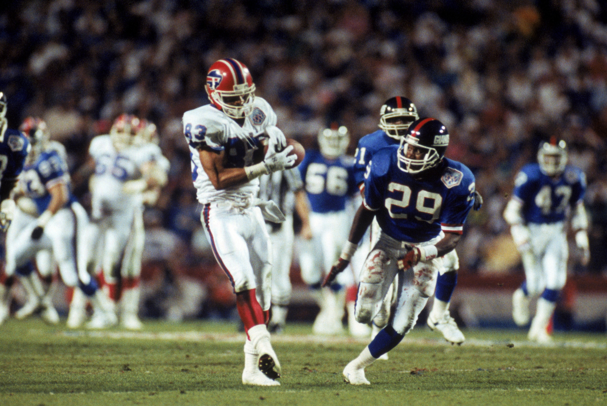 TAMPA, FL - JANUARY 27:  Wide receiver Andre Reed #83 of the Buffalo Bills starts to loose the ball against safety Myron Guyton #29 of the New York Giants in the second quarter of Super Bowl XXV at Tampa Stadium on January 27, 1991 in Tampa, Florida.  The