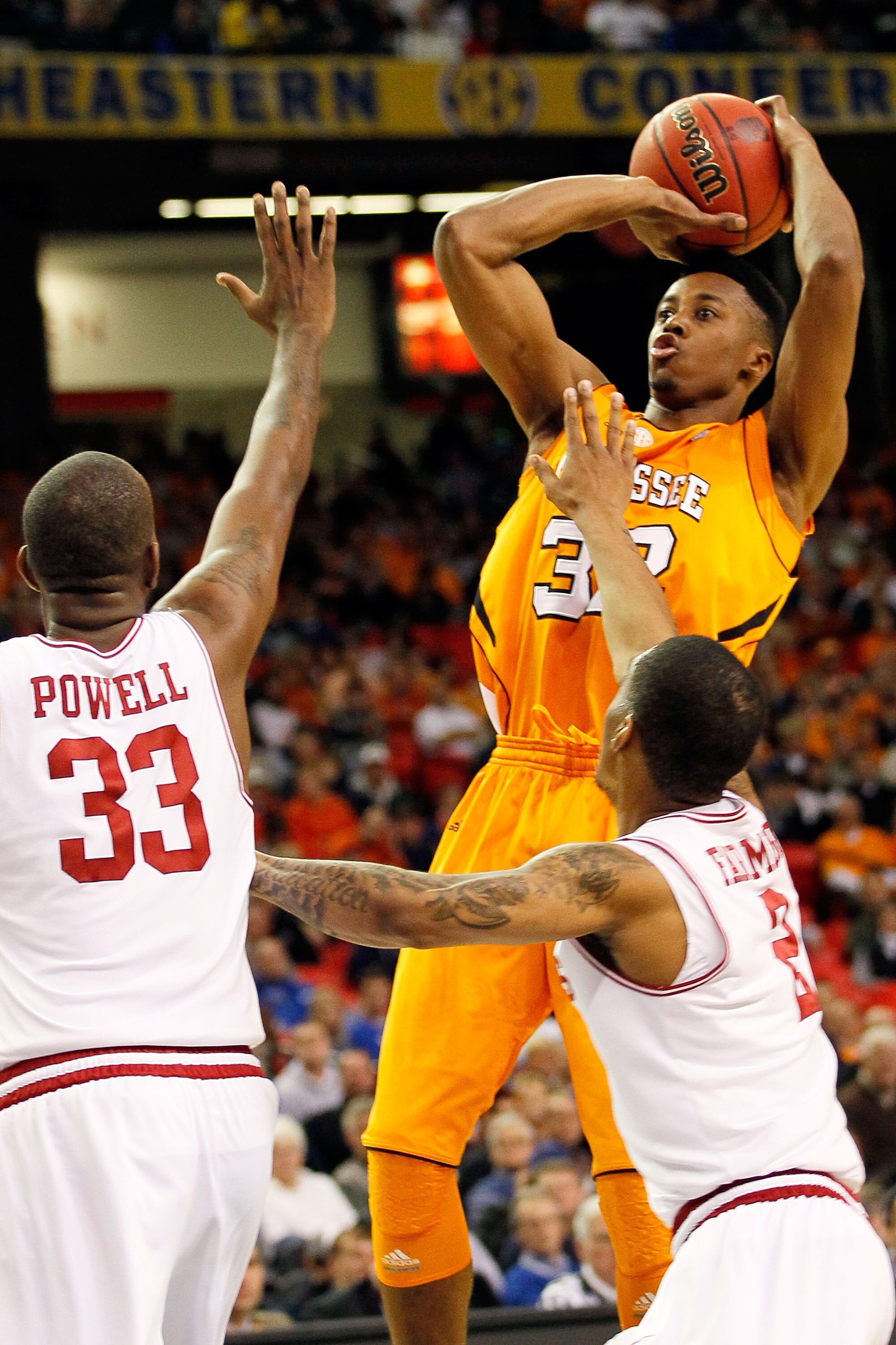 ATLANTA, GA - MARCH 10:  Scotty Hopson #32 of the Tennessee Volunteers shoots against Marshawn Powell #33 and Jemal Farmer #2 of the Arkansas Razorbacks during the first round of the SEC Men's Basketball Tournament at the Georgia Dome on March 10, 2011 in