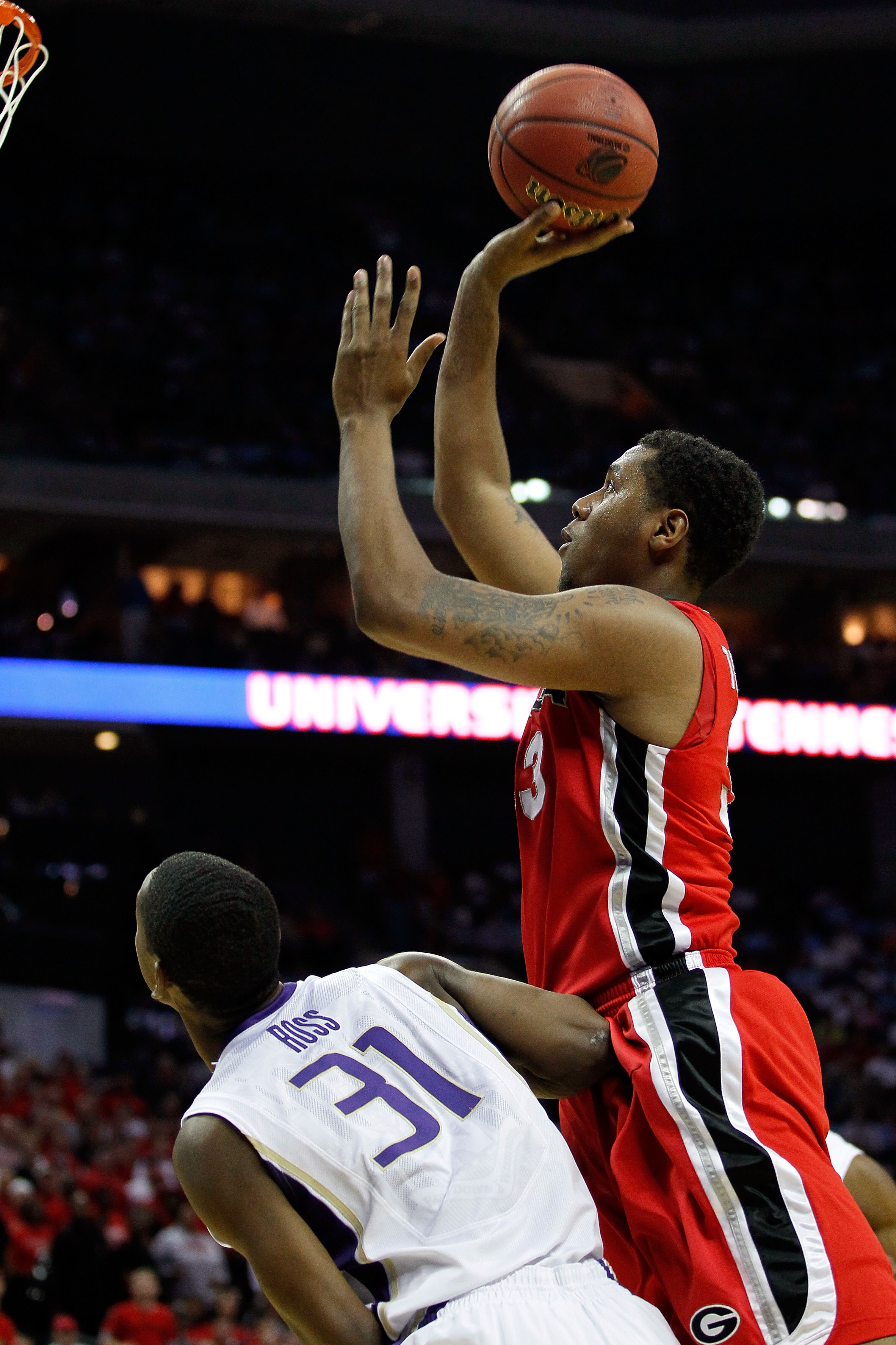 CHARLOTTE, NC - MARCH 18:  Trey Thompkins #33 of the Georgia Bulldogs shoots over Terrence Ross #31 of the Washington Huskies in the first half during the second round of the 2011 NCAA men's basketball tournament at Time Warner Cable Arena on March 18, 20
