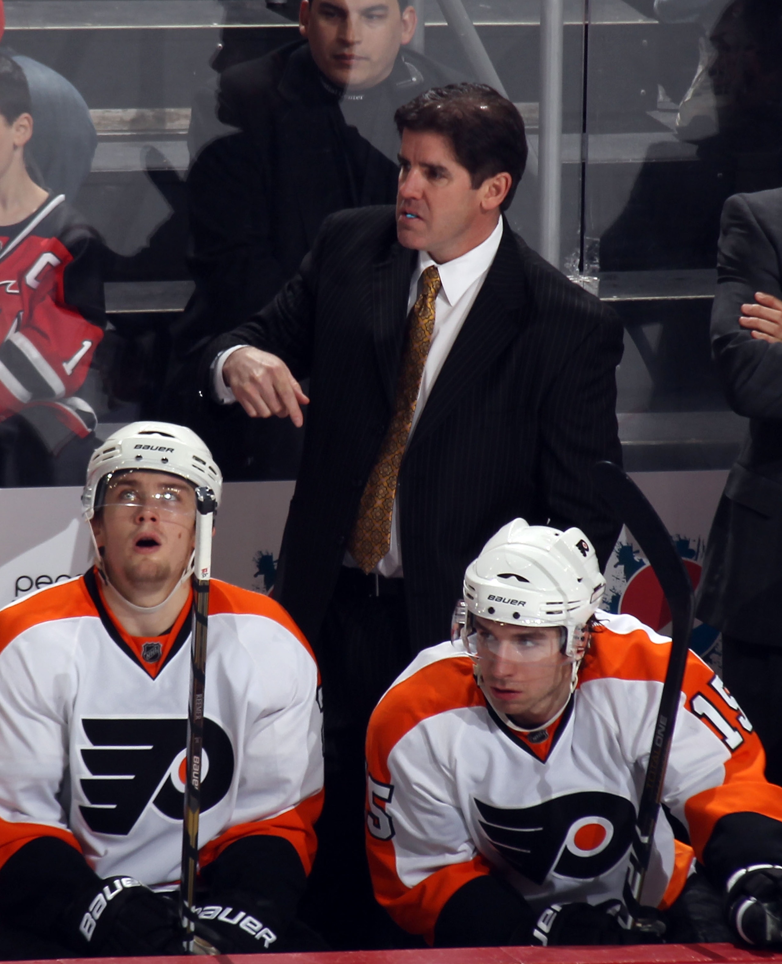 NEWARK, NJ - JANUARY 06:  Head coach Peter Laviolette of the Philadelphia Flyers gives his players instructions during the game against the New Jersey Devils at the Prudential Center on January 6, 2011 in Newark, New Jersey.  (Photo by Bruce Bennett/Getty