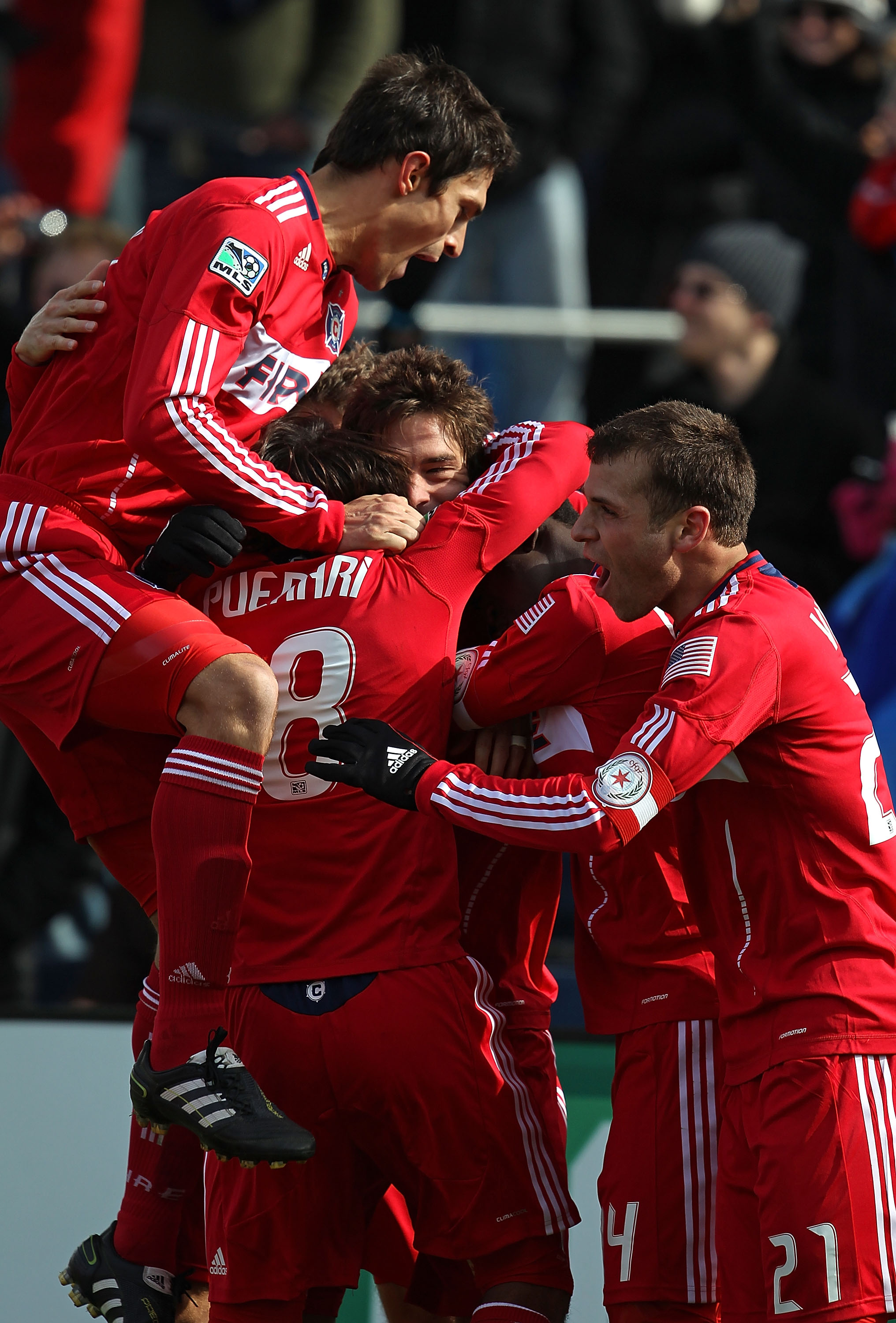 BRIDGEVIEW, IL - MARCH 26: Members of the Chicago Fire including Gaston Puerari #18, Patrick Nyarko #14 and Michael Videira #21 celebrate a goal with teammate Diego Chaves #99 (facing camera) against Sporting Kansas City during an MLS match at Toyota Park