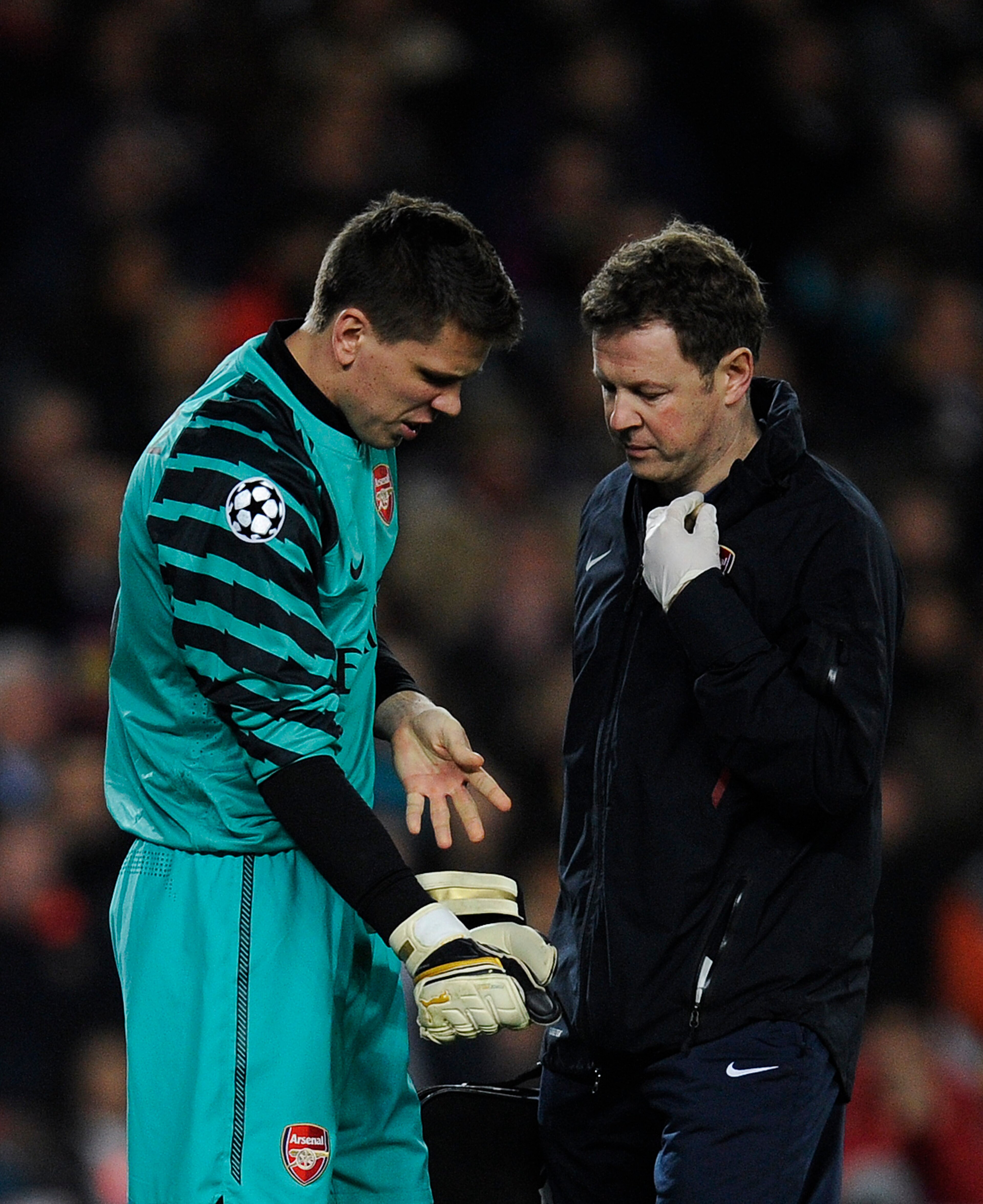 BARCELONA, SPAIN - MARCH 08: Wojciech Szczesny of Arsenal (L) receives treatment from a medic during the UEFA Champions League round of 16 second leg match between Barcelona and Arsenal at the Camp Nou stadium on March 8, 2011 in Barcelona, Spain. Barce BARCELONA, SPAIN - MARCH 08: Wojciech Szczesny of Arsenal (L) receives treatment from a medic during the UEFA Champions League round of 16 second leg match between Barcelona and Arsenal at the Camp Nou stadium on March 8, 2011 in Barcelona, Spain. Barce