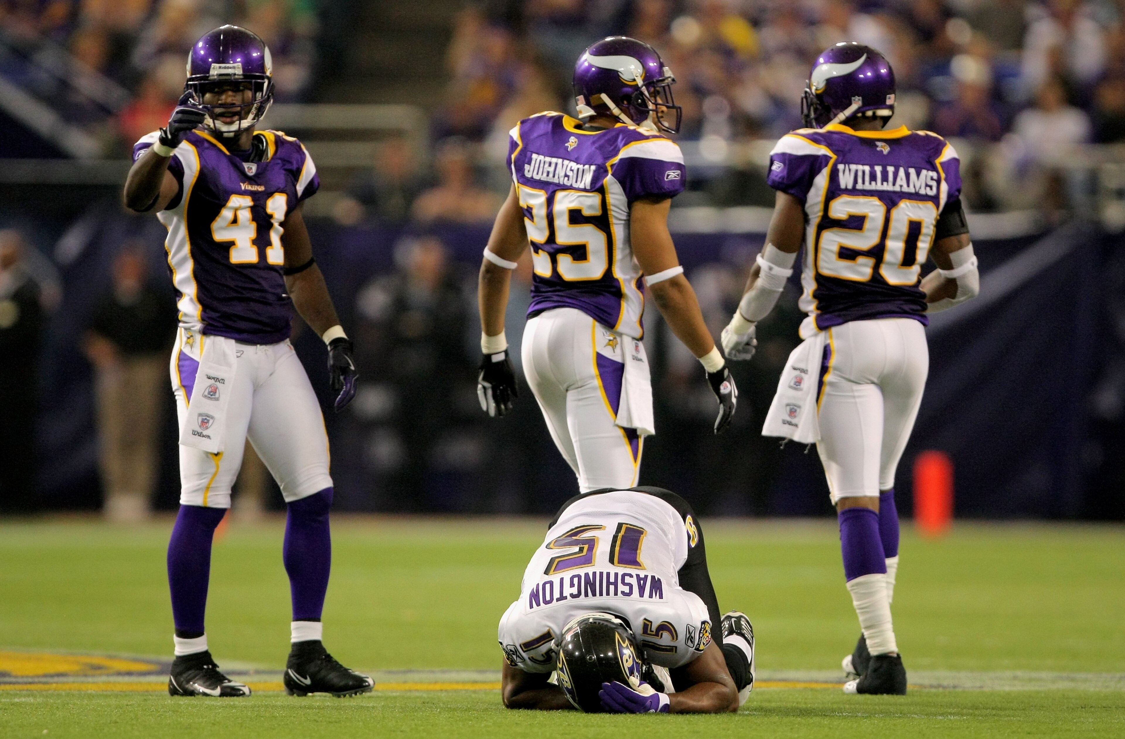 MINNEAPOLIS - OCTOBER 18: Wide reciever Kelley Washington #15 of the Baltimore Ravens is shaken up after making a reception as Karl Paymah #41, Tyrell Johnson #25 and Madieu Williams #20 of the Minnesota Vikings walk away after the play during NFL action MINNEAPOLIS - OCTOBER 18: Wide reciever Kelley Washington #15 of the Baltimore Ravens is shaken up after making a reception as Karl Paymah #41, Tyrell Johnson #25 and Madieu Williams #20 of the Minnesota Vikings walk away after the play during NFL action