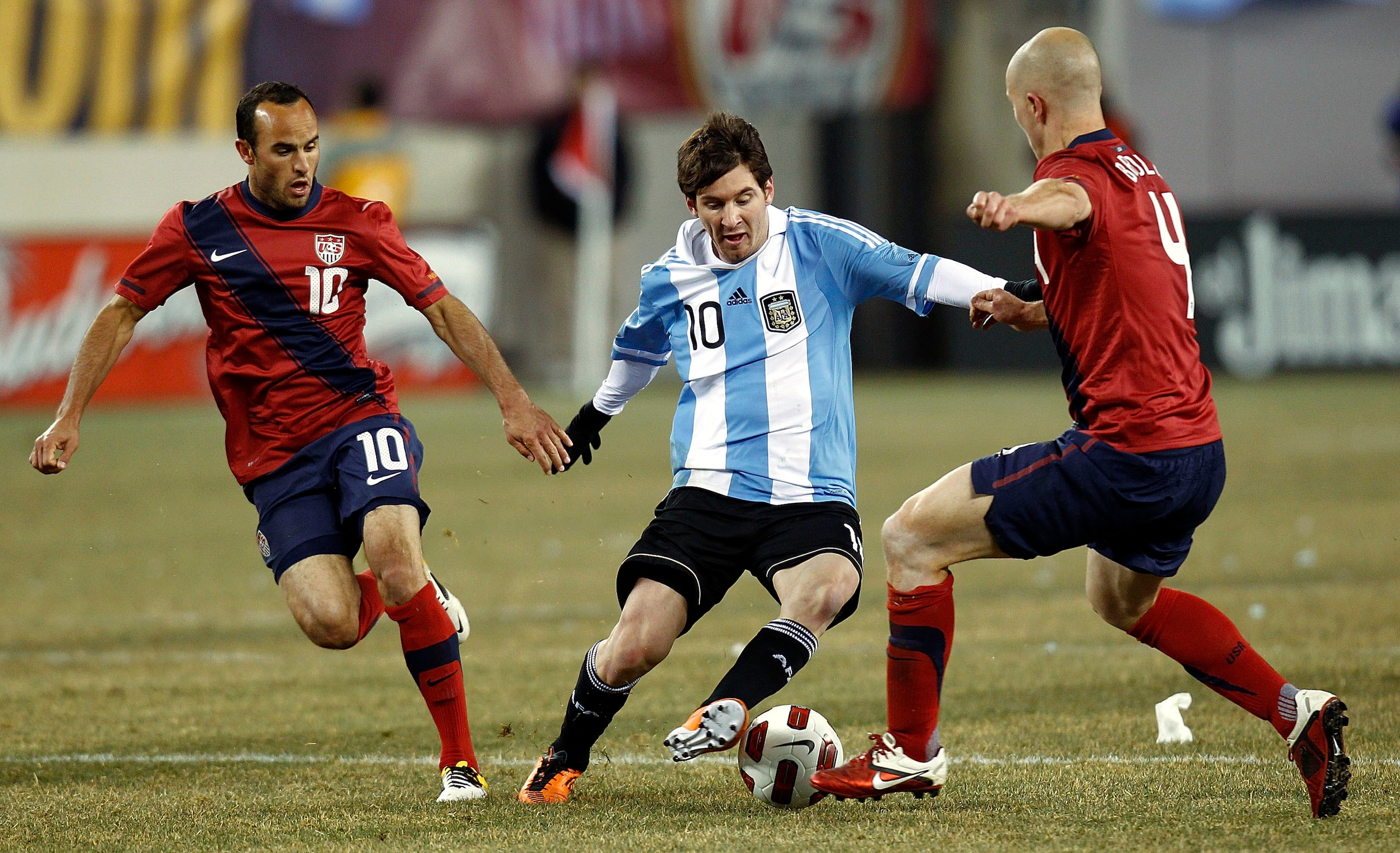 EAST RUTHERFORD, NJ - MARCH 26:  Lionel Messi #10 of Argentina dribbles between Landon Donovan #10 and Michael Bradley #4 of the United States during the first half of a friendly match at New Meadowlands Stadium on March 26, 2011 in East Rutherford, New J