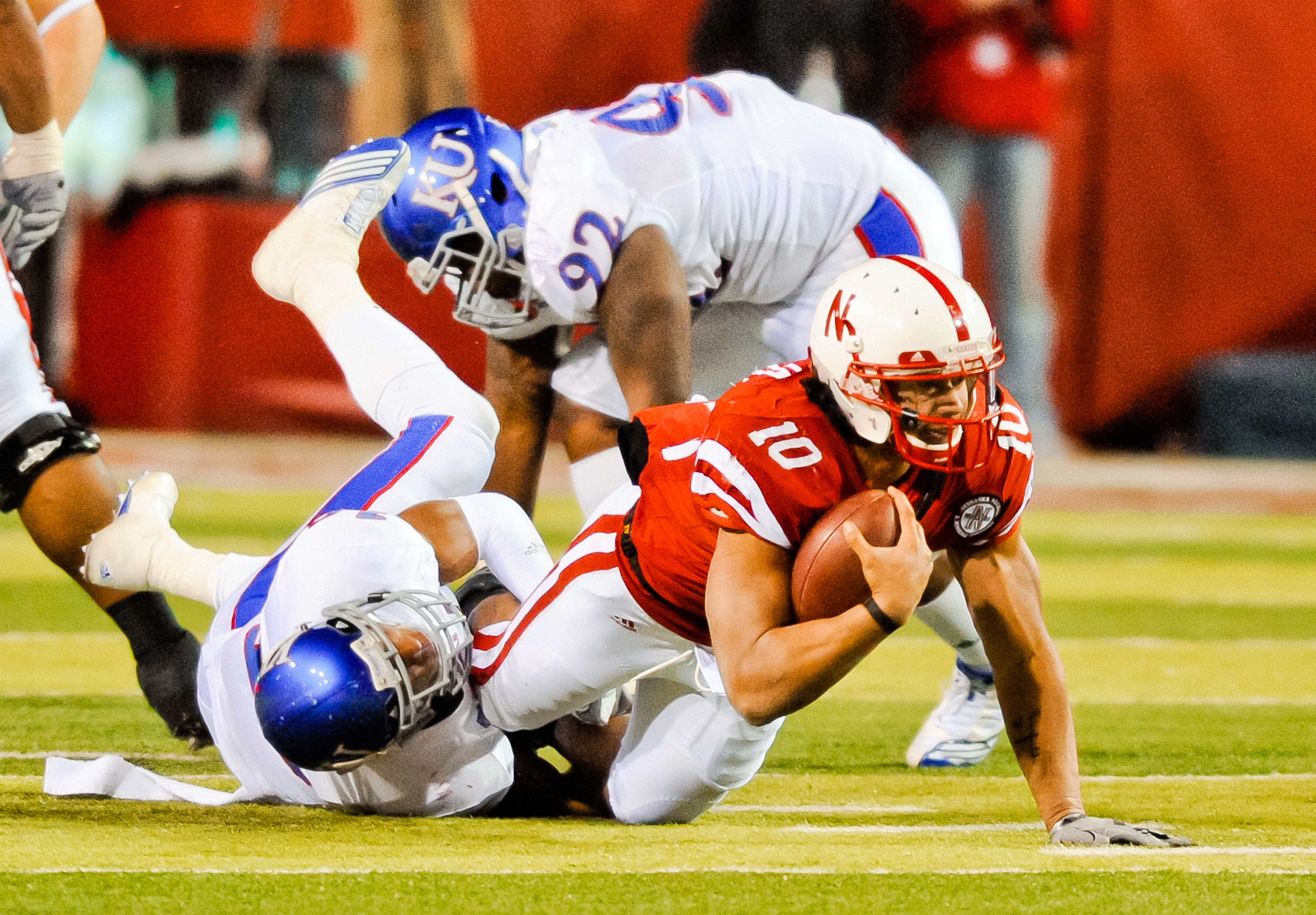 LINCOLN, NE - NOVEMBER 13: Roy Helu Jr. #10 of the Nebraska Cornhuskers is brought down by Isiah Barfield #19 of the Kansas Jayhawks during their game at Memorial Stadium on November 13, 2010 in Lincoln, Nebraska. Nebraska Defeated Kansas 20-3. (Photo by