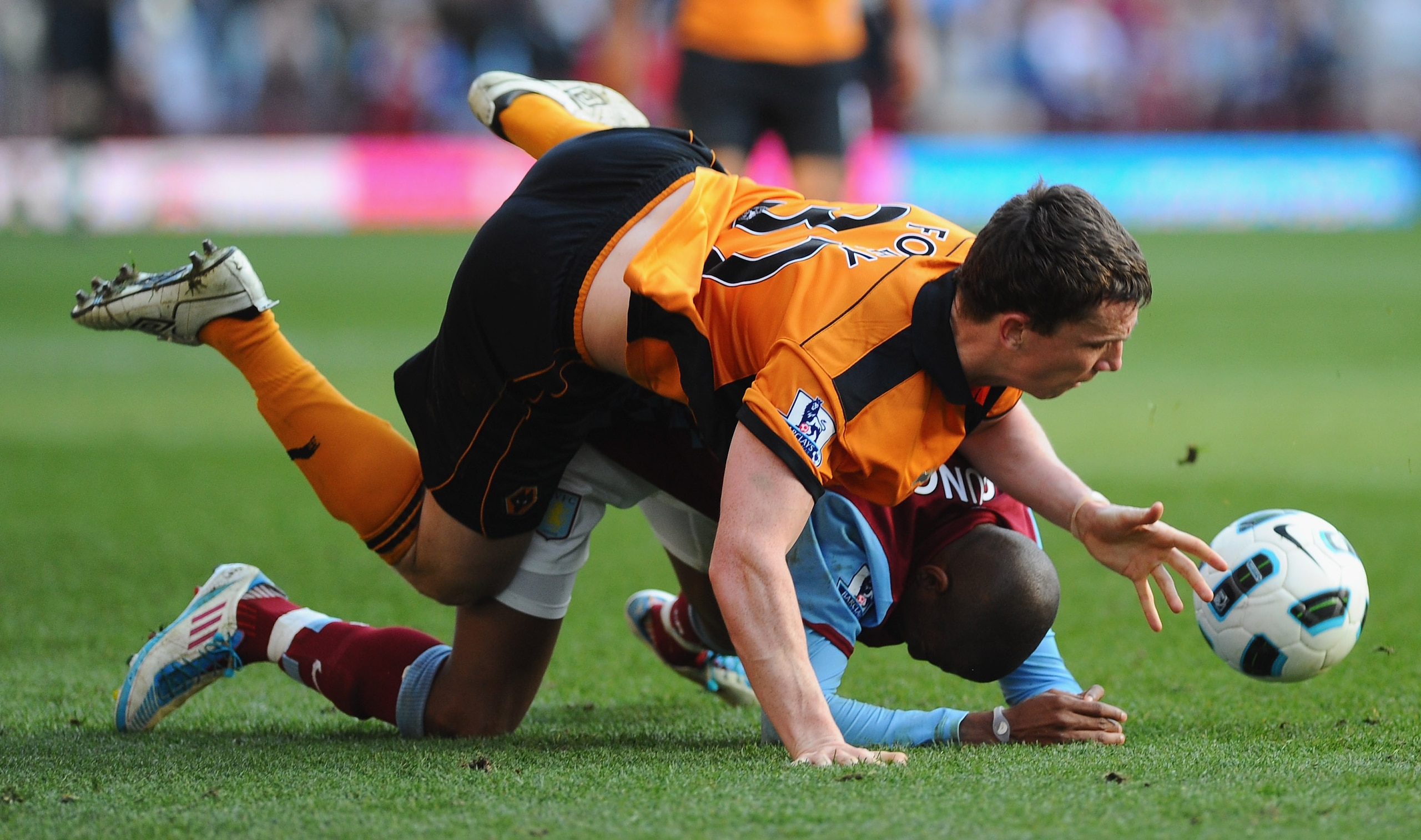 BIRMINGHAM, ENGLAND - MARCH 19:  Ashley Young of Aston Villa is flattened by Kevin Foley of Wolves during the Barclays Premier League match between Aston Villa and Wolverhampton Wanderers at Villa Park on March 19, 2011 in Birmingham, England.  (Photo by