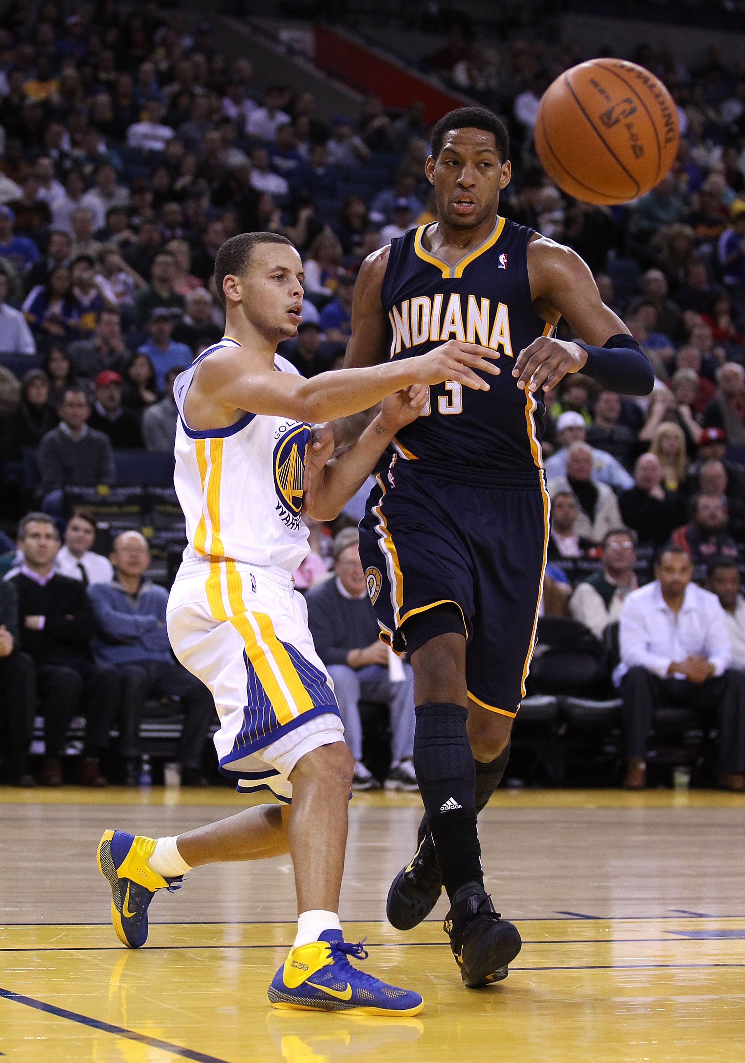 OAKLAND, CA - JANUARY 19:  Stephen Curry #30 of the Golden State Warriors passes the ball around Danny Granger #33 of the Indiana Pacers at Oracle Arena on January 19, 2011 in Oakland, California.  NOTE TO USER: User expressly acknowledges and agrees that