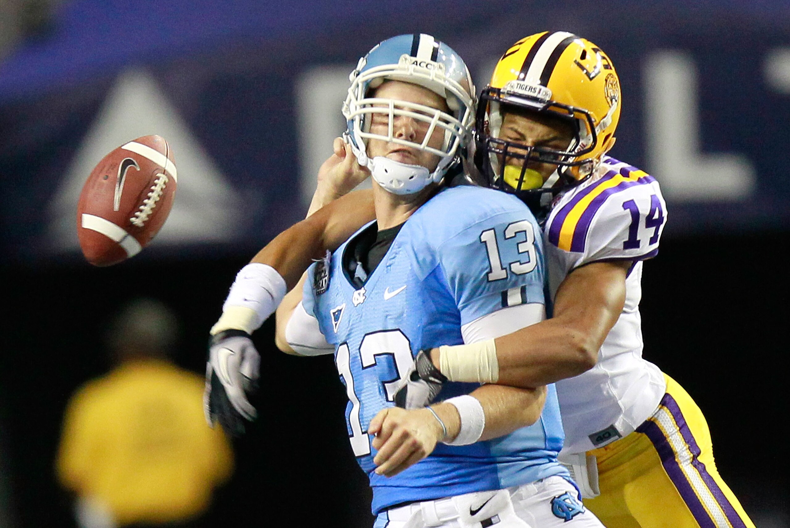 ATLANTA - SEPTEMBER 04:  Tyrann Mathieu #14 of the LSU Tigers forces a fumble by quarterback T.J. Yates #13 of the North Carolina Tar Heels during the Chick-fil-A Kickoff Game at Georgia Dome on September 4, 2010 in Atlanta, Georgia.  (Photo by Kevin C. C