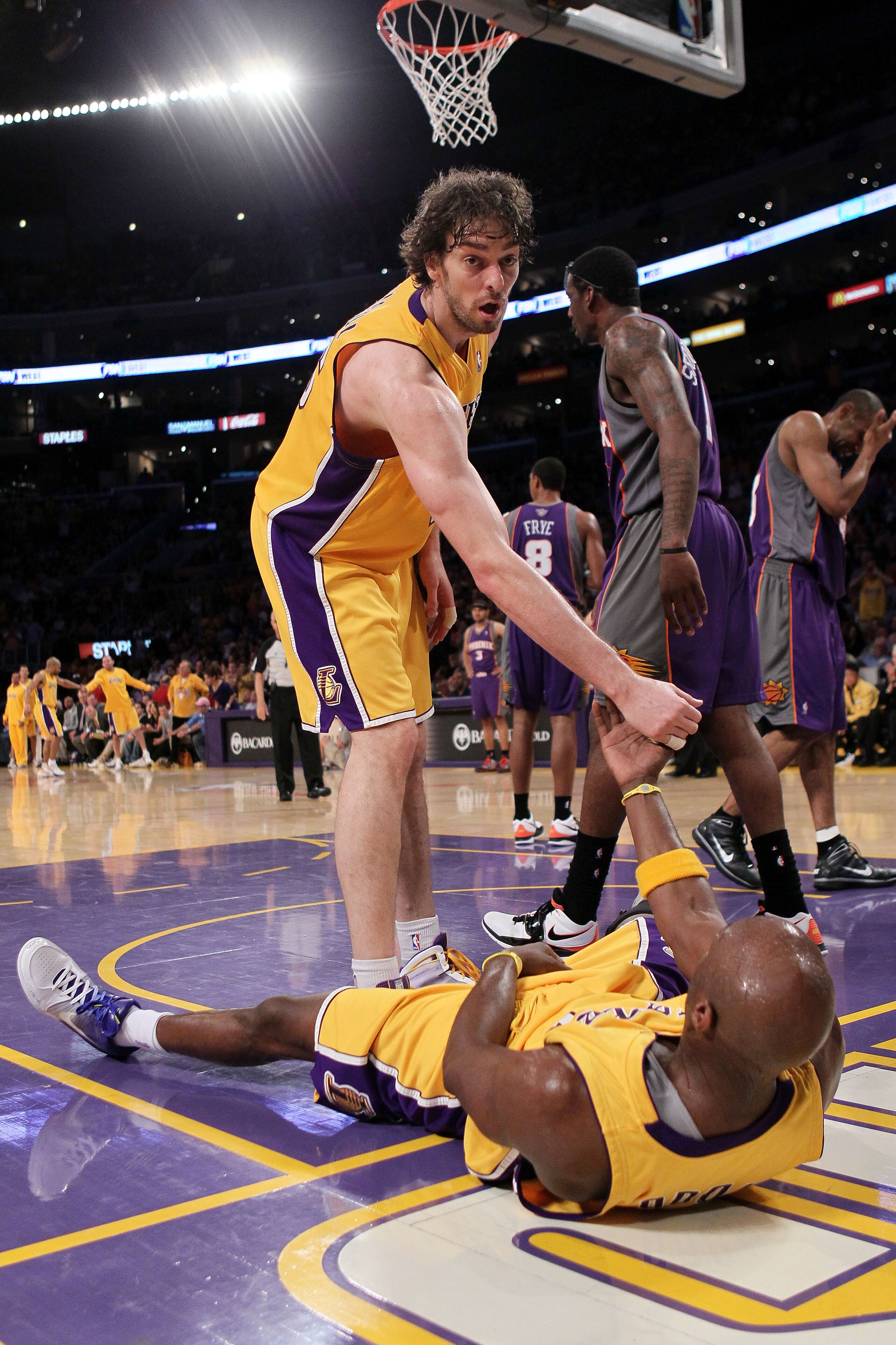 LOS ANGELES, CA - MAY 27:  Pau Gasol #16 of the Los Angeles Lakers helps teammate Lamar Odom #7 up after a play against the Phoenix Suns in the third quarter of Game Five of the Western Conference Finals during the 2010 NBA Playoffs at Staples Center on M