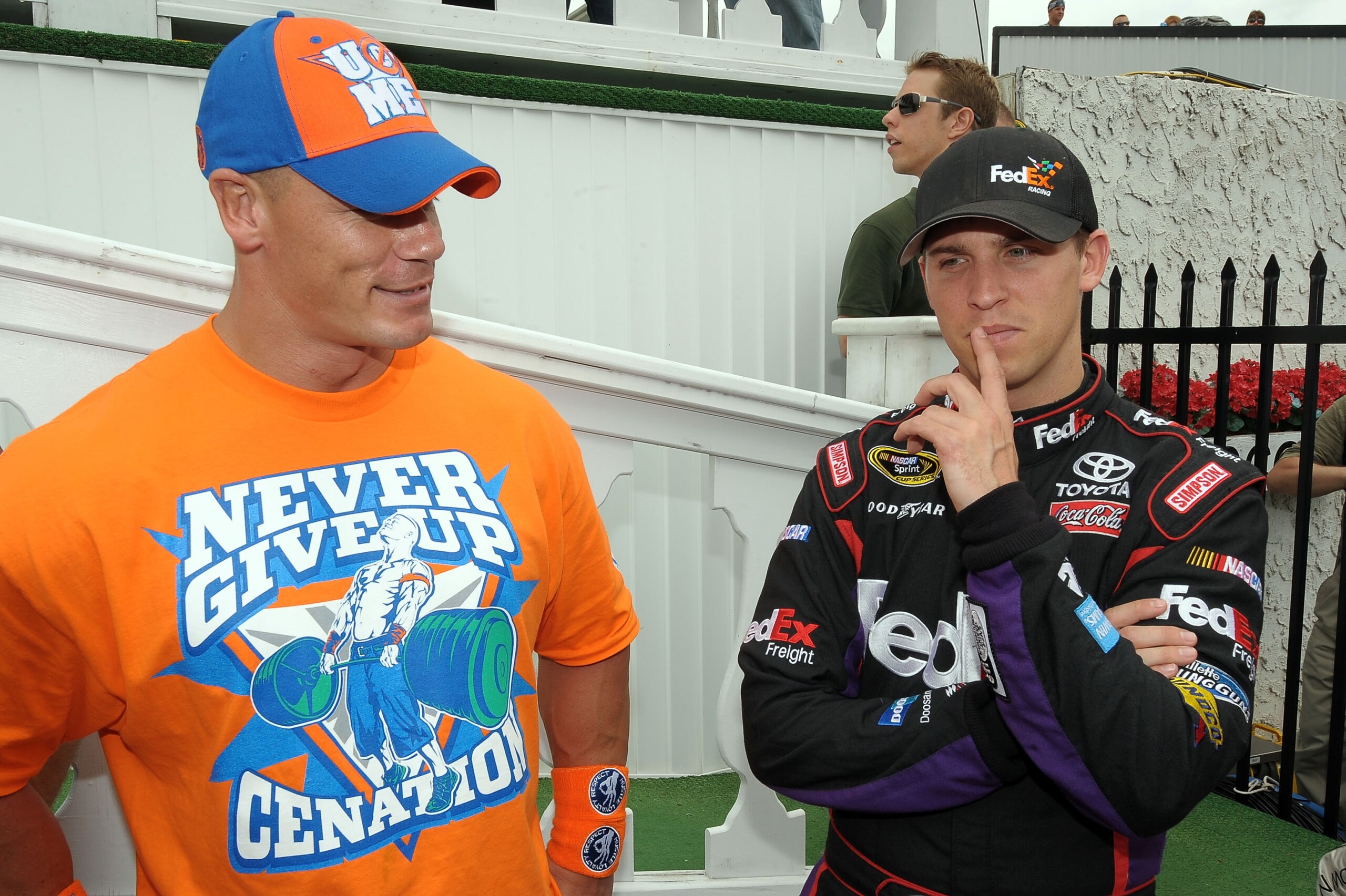 LONG POND, PA - JUNE 06:  WWE champion and co-grand marshal John Cena (L) and Denny Hamlin, driver of the #11 FedEx Freight Toyota, talk in Victory Lane prior to the NASCAR Sprint Cup Series Gillette Fusion ProGlide 500 at Pocono Raceway on June 6, 2010 i