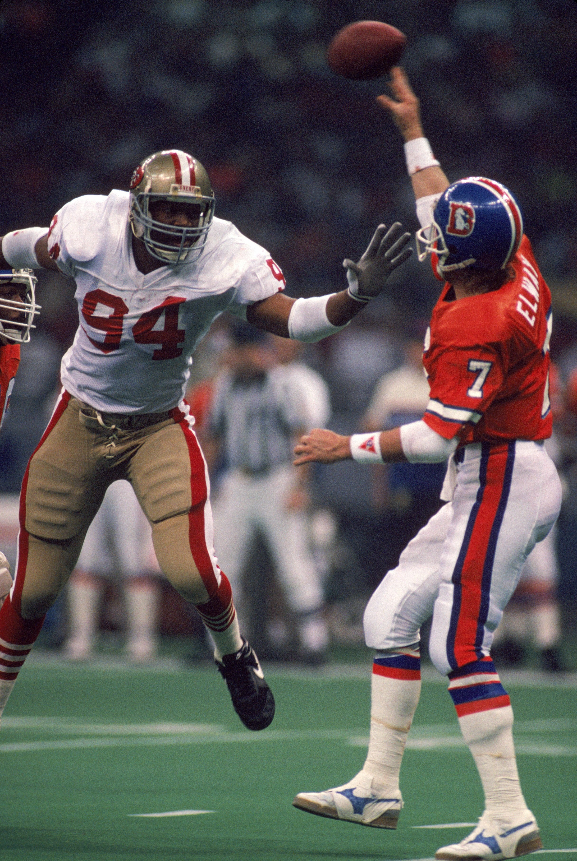NEW ORLEANS - JANUARY 28:  Defensive end Charles Haley #94 of the San Francisco 49ers pressures Denver Broncos quarterback John Elway #7 in Super Bowl XXIV at Louisiana Superdome on January 28, 1990 in New Orleans, Louisiana.  The 49ers won 55-10.  (Photo