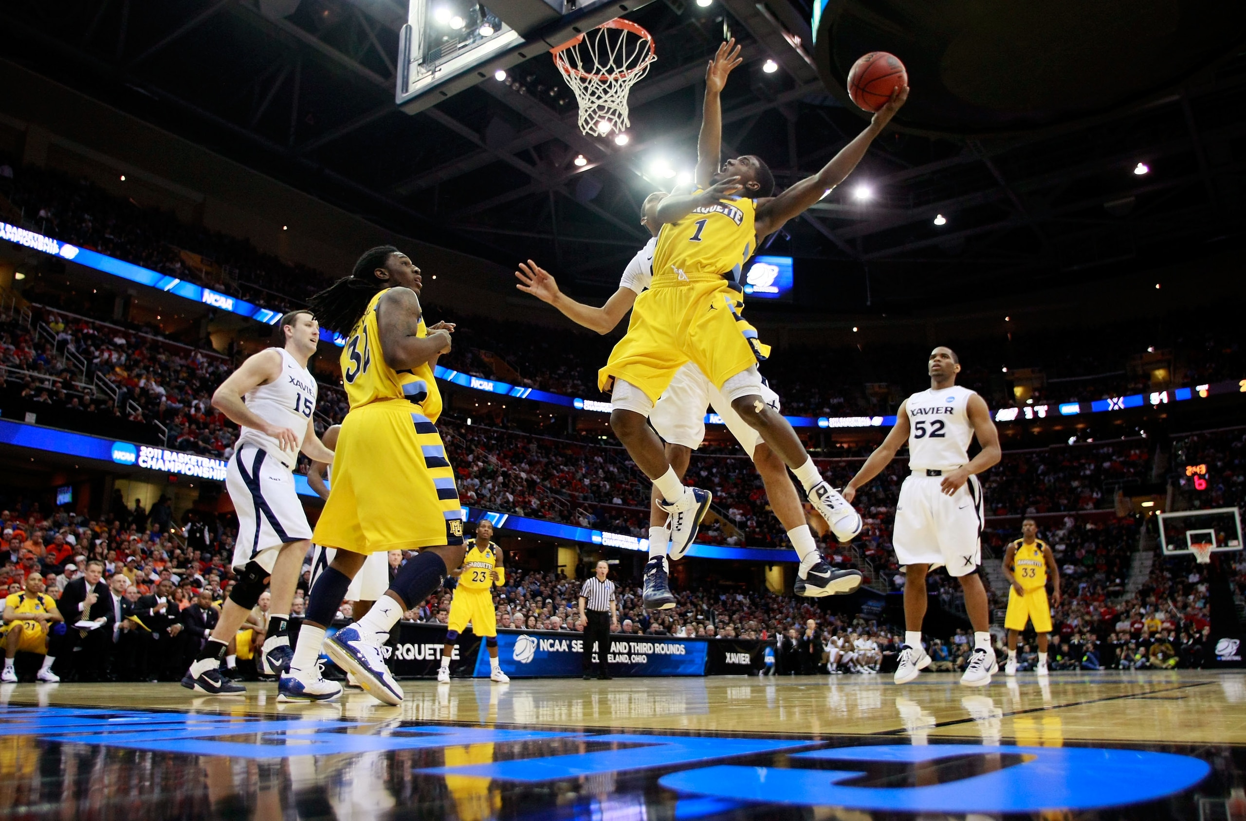 CLEVELAND, OH - MARCH 18: Darius Johnson-Odom #1 of the Marquette Golden Eagles drives to the basket against Jeff Robinson #21 of the Xavier Musketeers during the second round of the 2011 NCAA men's basketball tournament at Quicken Loans Arena on March 18
