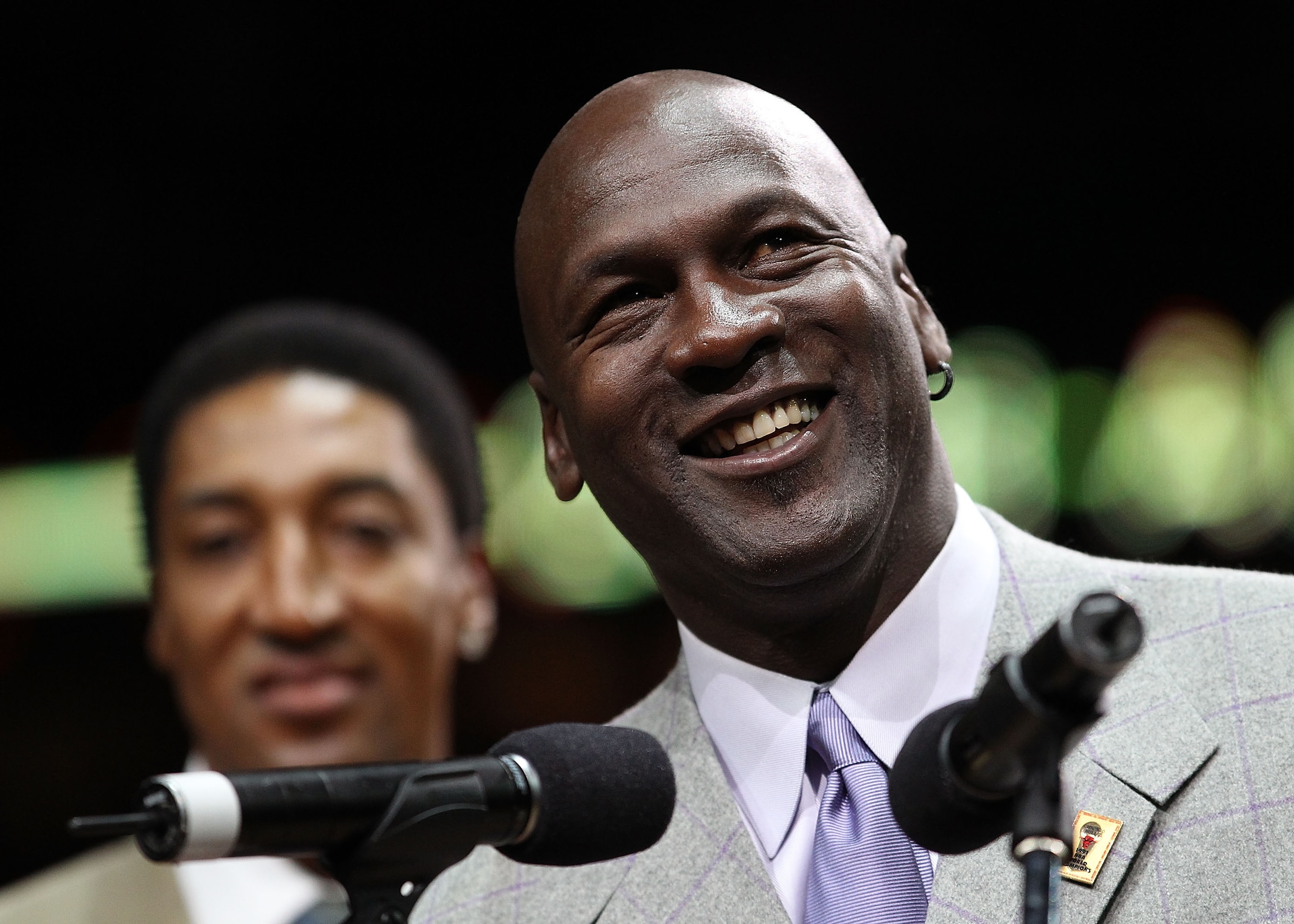 CHICAGO, IL - MARCH 12: Former player Michael Jordan of the Chicago Bulls addresses the crowd as teammate Scottie Pippen listens during a 20th anniversary recognition ceremony of the Bulls 1st NBA Championship in 1991 during half-time of a game bewteen th