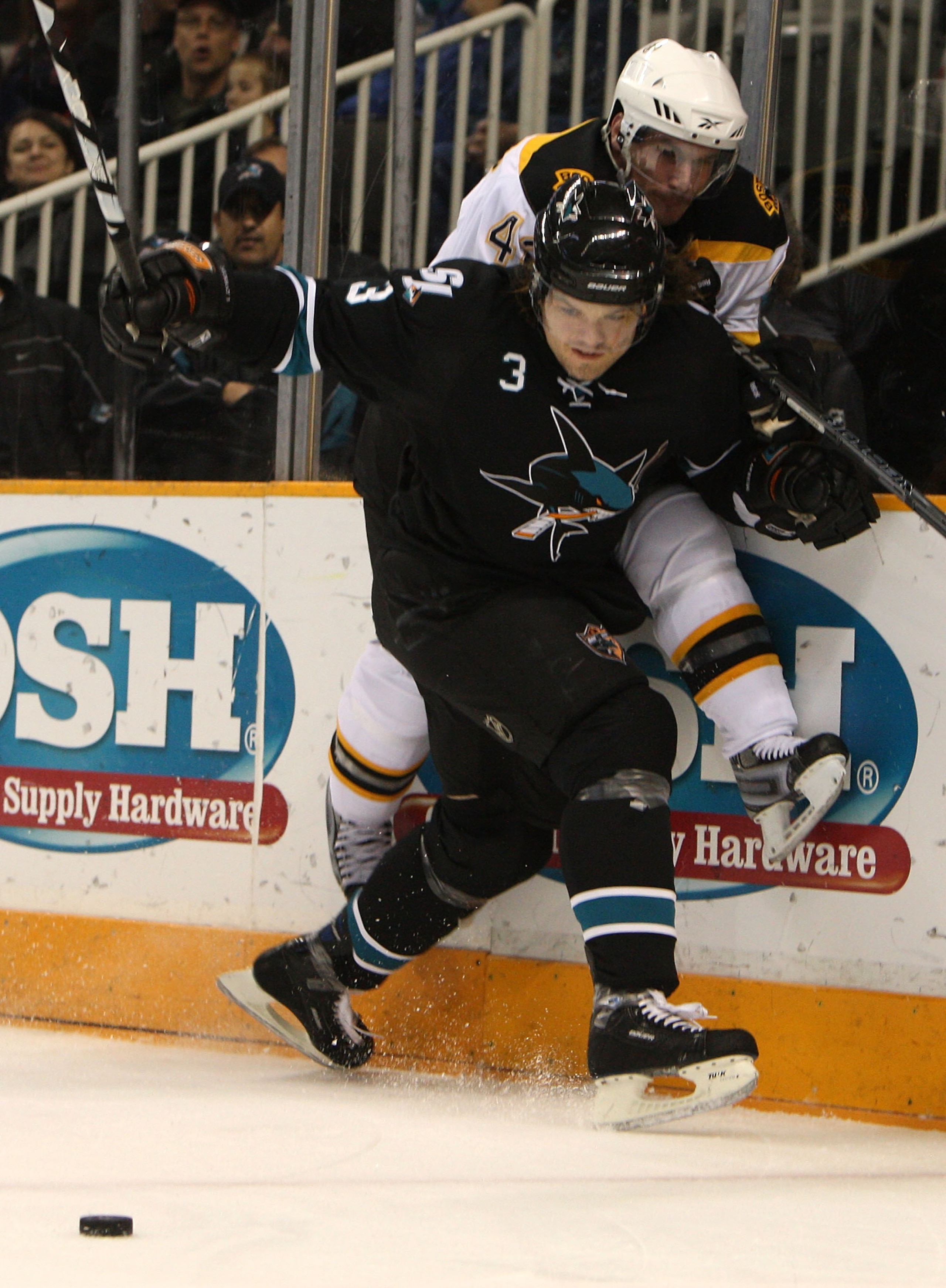 SAN JOSE, CA - JANUARY 14:  Douglas Murray #3 of the San Jose Sharks battles for the puck with Trent Whitfield #42 of the Boston Bruins during an NHL game at the HP Pavilion on January 14, 2010 in San Jose, California.  (Photo by Jed Jacobsohn/Getty Image