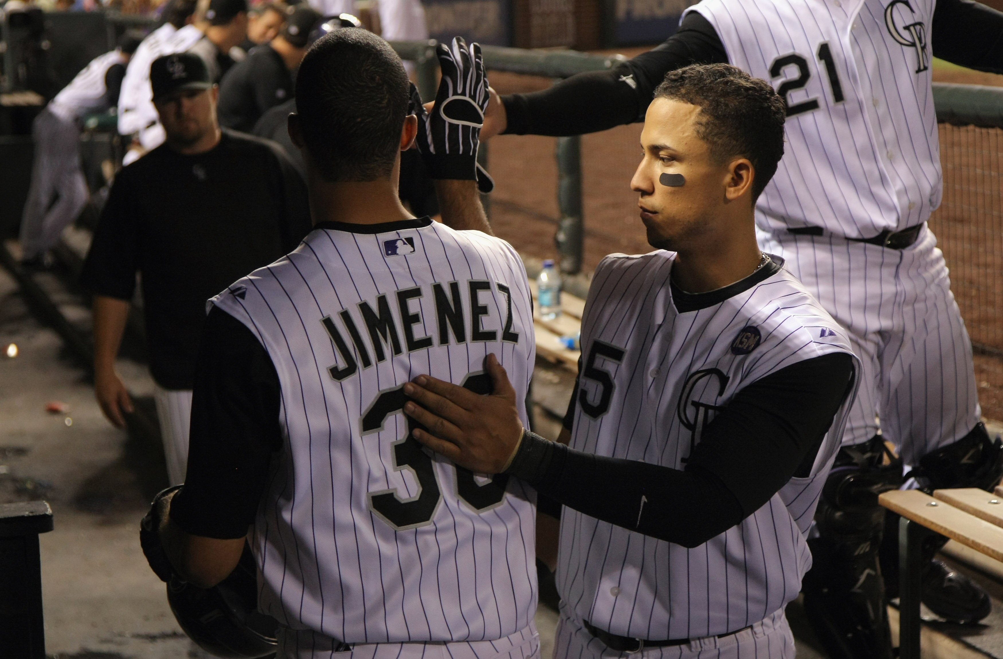 DENVER - SEPTEMBER 27:  Starting pitcher Ubaldo Jimenez #38 of the Colorado Rockies is welcomed back to the dugout by Carlos Gonzalez #5 after a successful sacrifice bunt against the Los Angeles Dodgers at Coors Field on September 25, 2010 in Denver, Colo