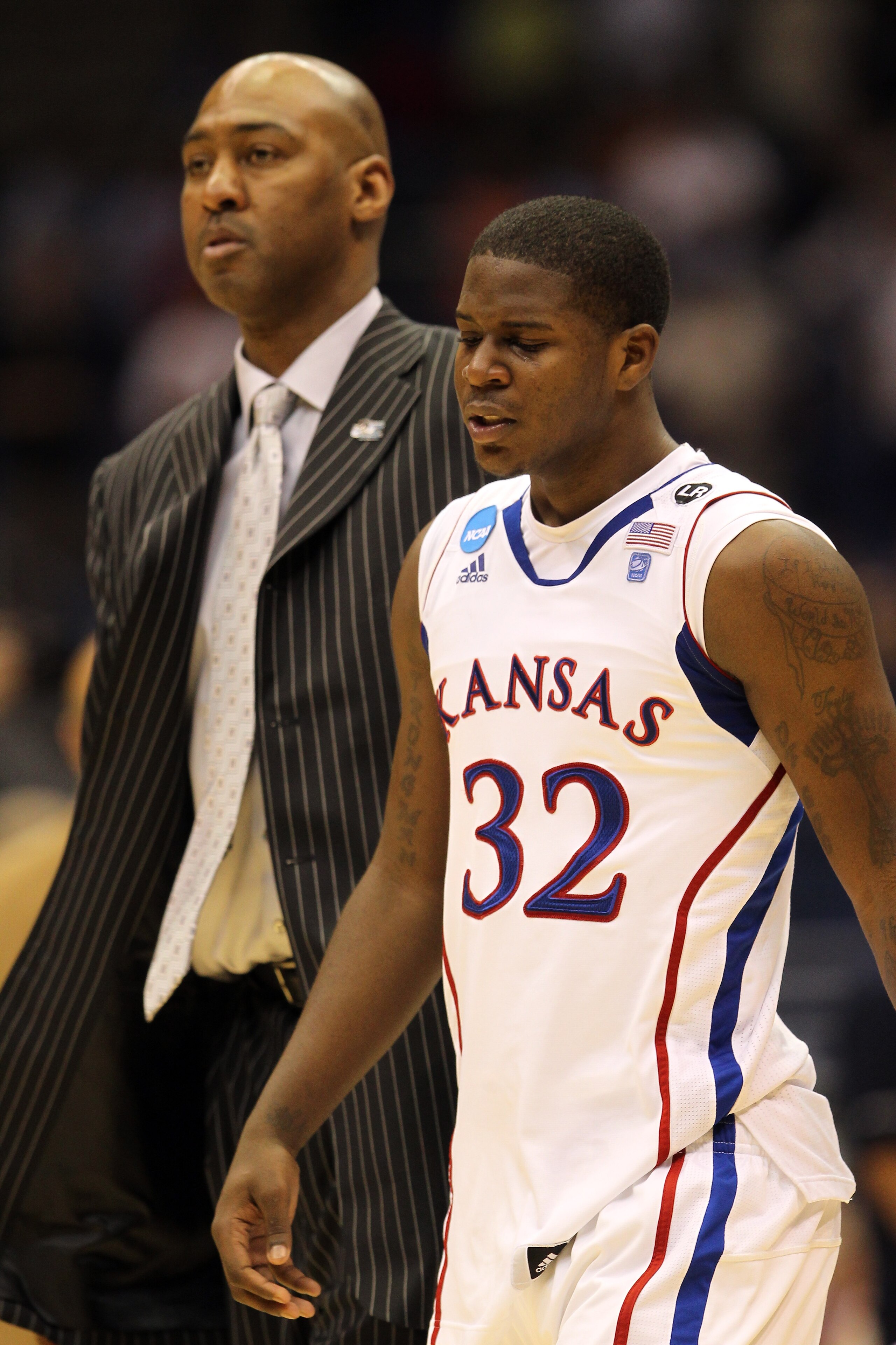 SAN ANTONIO, TX - MARCH 27:  Josh Selby #32 of the Kansas Jayhawks and assistant coach Danny Manning react after the southwest regional final of the 2011 NCAA men's basketball tournament against the Virginia Commonwealth Rams at the Alamodome on March 27,