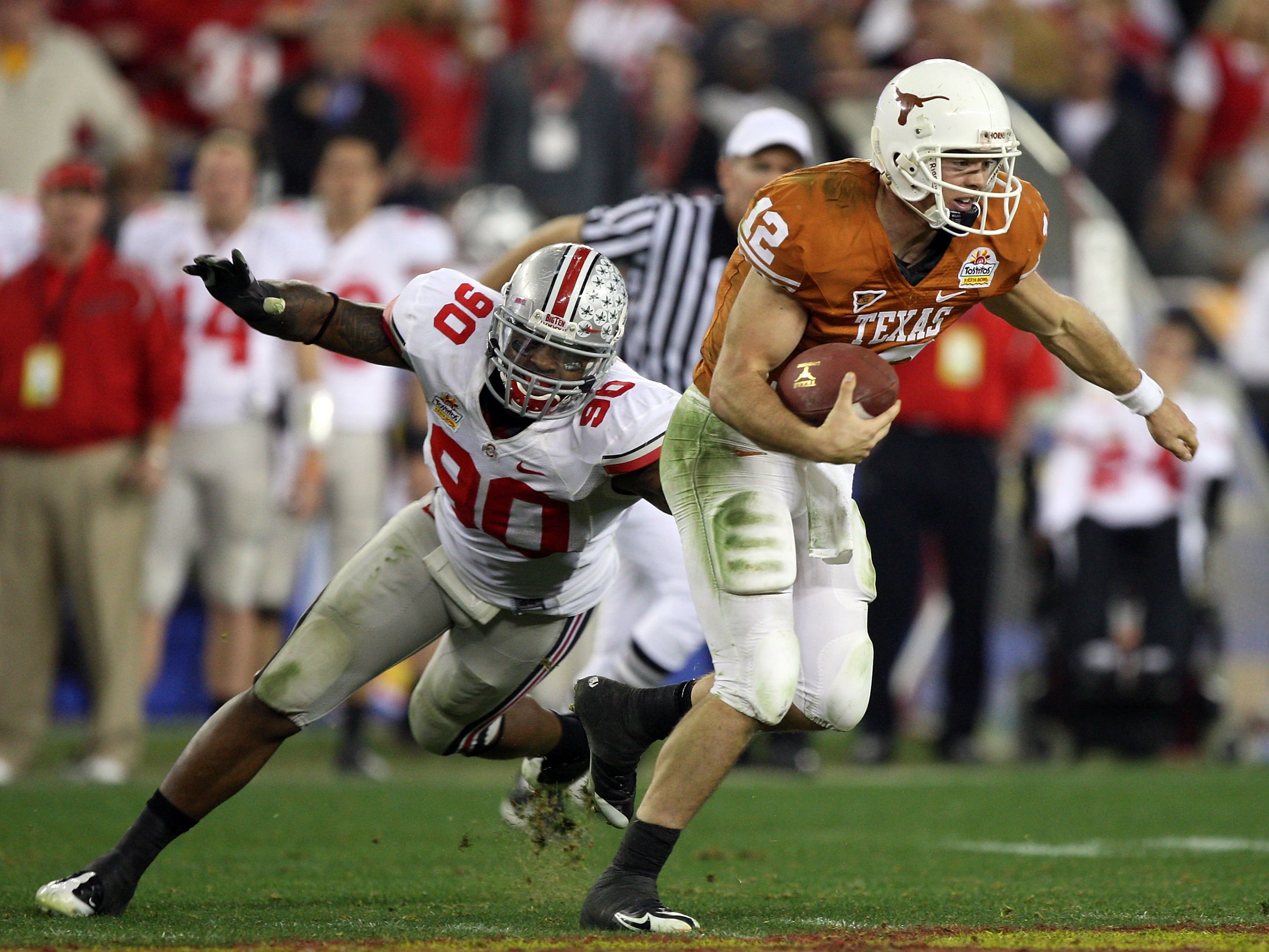 GLENDALE, AZ - JANUARY 05:  Quarterback Colt McCoy #12 of the Texas Longhorns scrambles from Thaddeus Gibson #90 of the Ohio State Buckeyes in the Tostitos Fiesta Bowl Game on January 5, 2009 at University of Phoenix Stadium in Glendale, Arizona. The Long