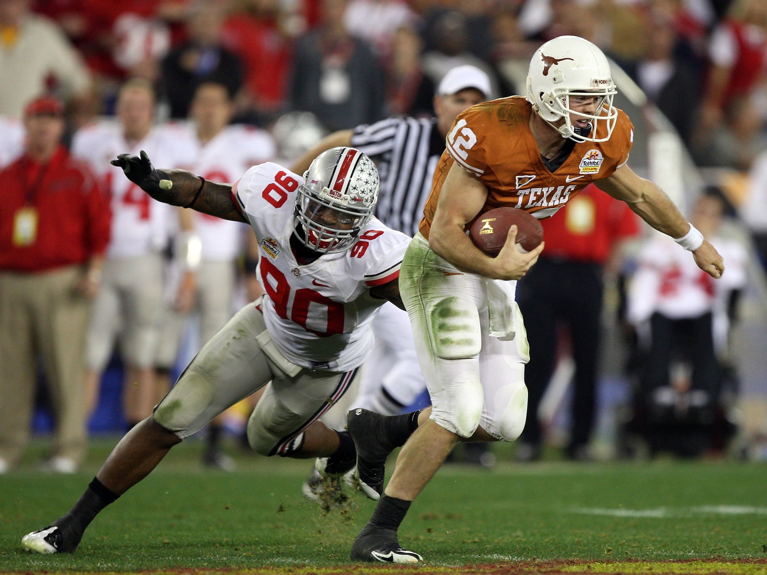GLENDALE, AZ - JANUARY 05:  Quarterback Colt McCoy #12 of the Texas Longhorns scrambles from Thaddeus Gibson #90 of the Ohio State Buckeyes in the Tostitos Fiesta Bowl Game on January 5, 2009 at University of Phoenix Stadium in Glendale, Arizona. The Long