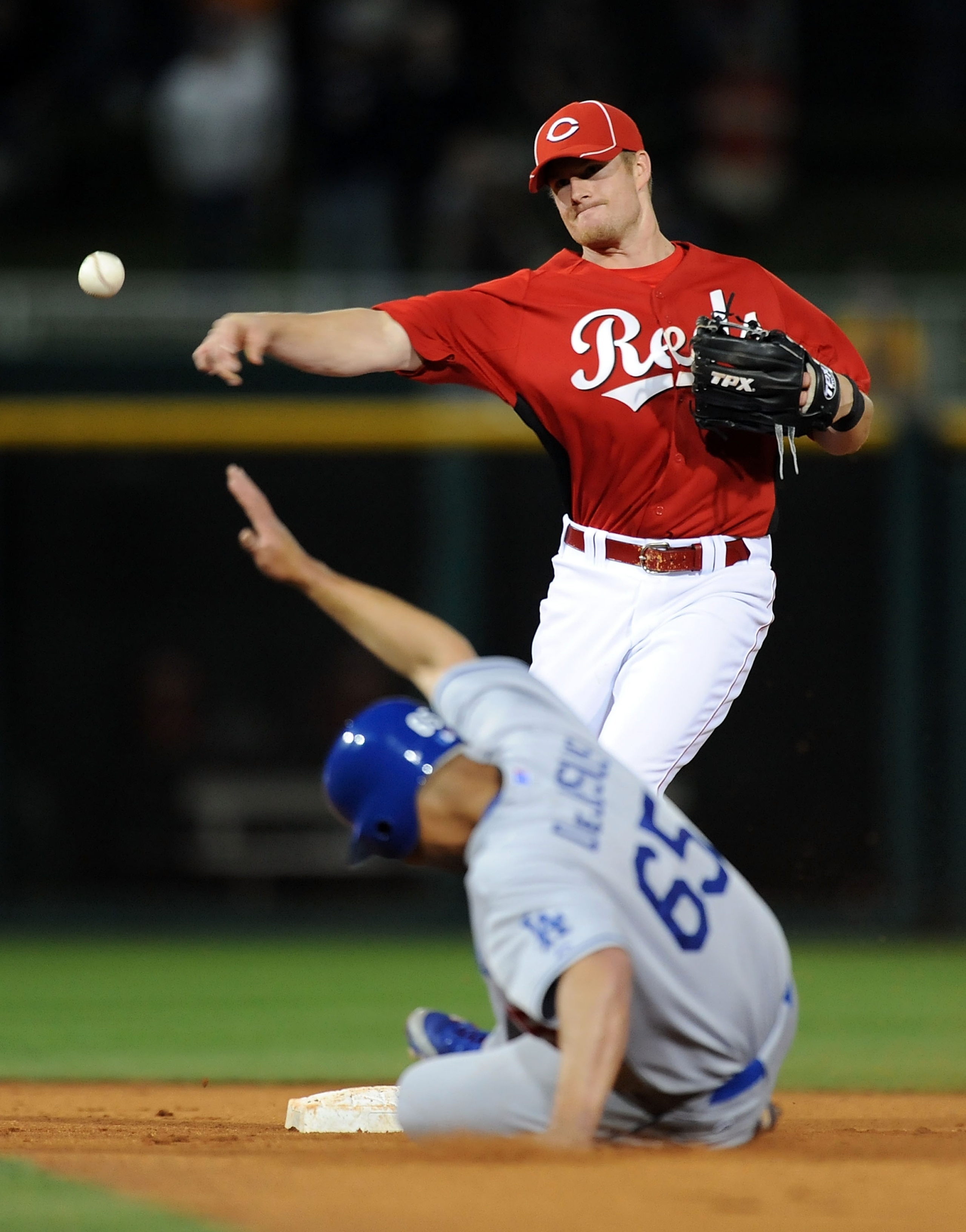GOODYEAR, AZ - MARCH 03: Zack Cozart #60 of the Cincinnati Reds turns a double play as Ivan De Jesus #65 of the Los Angeles Dodgers slides into second base at Goodyear Ballpark on March 3, 2011 in Goodyear, Arizona.  (Photo by Norm Hall/Getty Images)