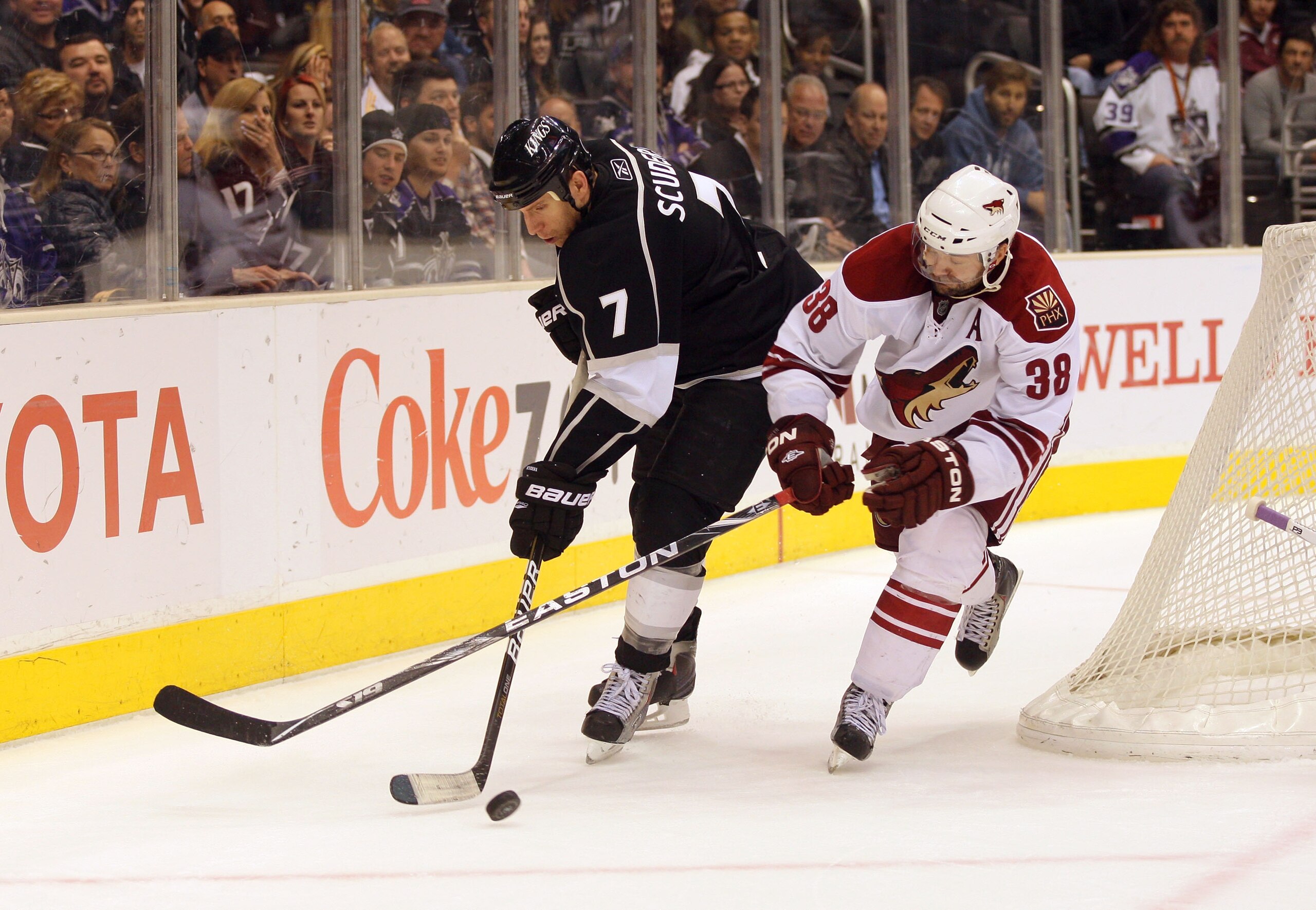 LOS ANGELES, CA - MARCH 03:  Rob Scuderi #7 of the Los Angeles Kings plays the puck behind the net under pressure from Vernon Fiddler #38 of the Phoenix Coyotes during the NHL game at Staples Center on March 3, 2011 in Los Angeles, California. The Kings d