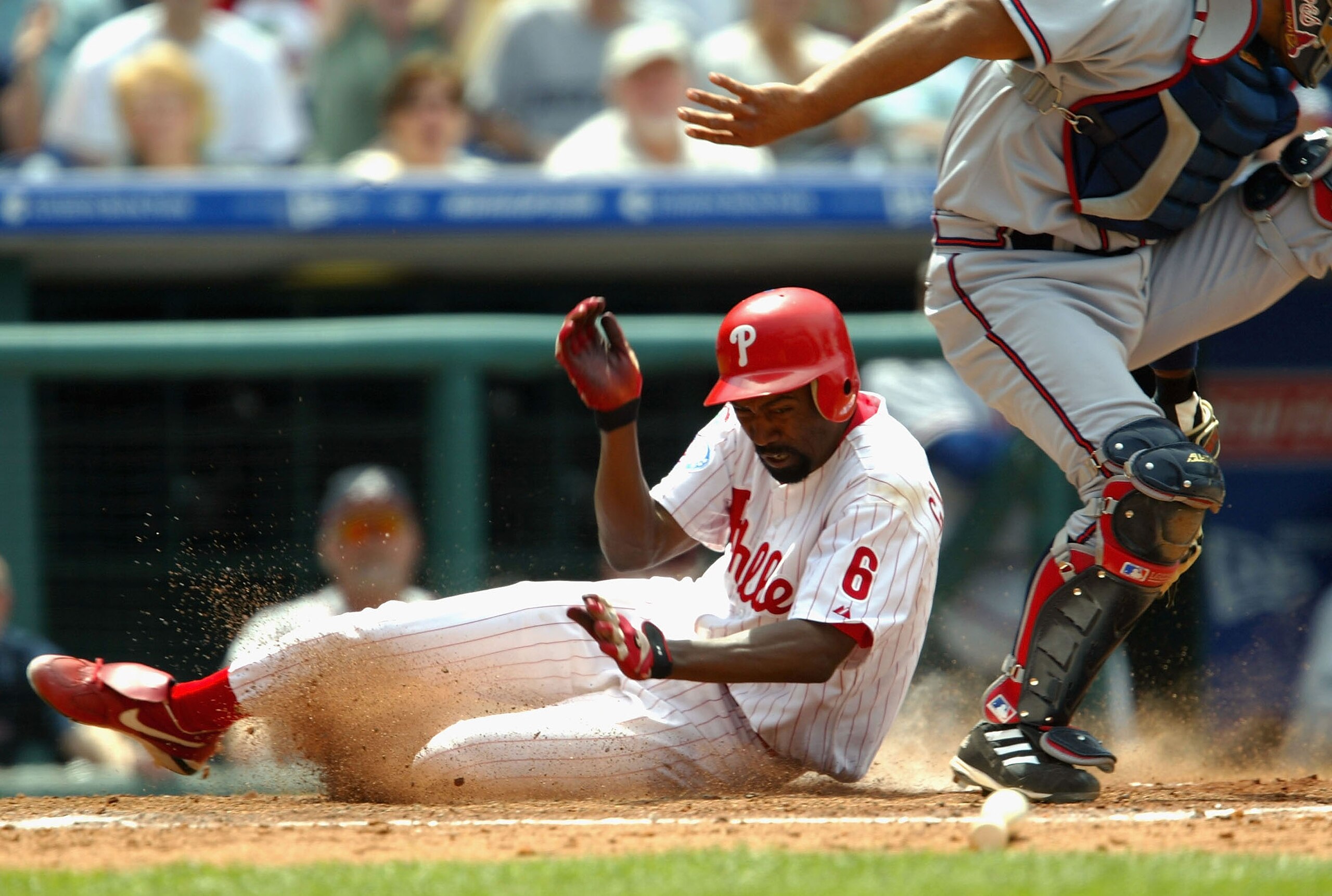 PHILADELPHIA  - MAY 29:  Doug Glanville #6 of the Philadelphia Phillies slides into home as catcher Johnny Estrada #23 of the Atlanta Braves attempts to guard the plate on May 29, 2004 at Citizens Bank Park in Philadelphia, Pennsylvania.  (Photo by Jamie