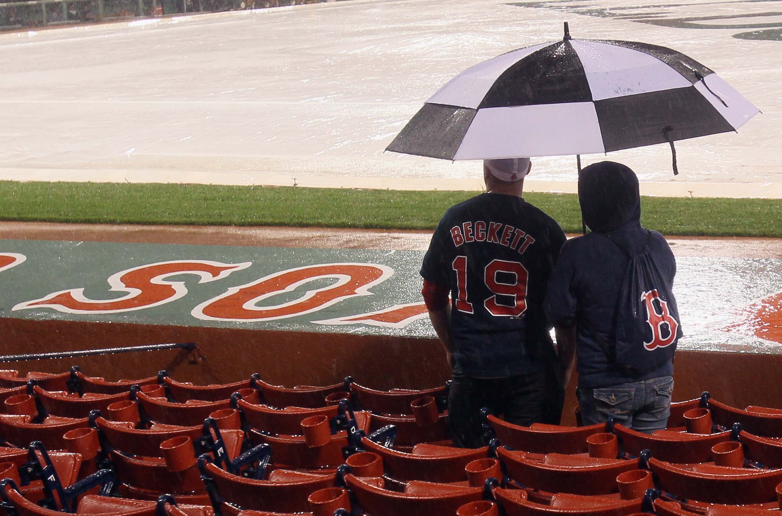 BOSTON - OCTOBER 01:  Fans patiently wait to hear that game between Boston Red Sox and the New York Yankees is postponed until tomorrow due to rain on October 1, 2010 at Fenway Park in Boston, Massachusetts.  (Photo by Elsa/Getty Images)
