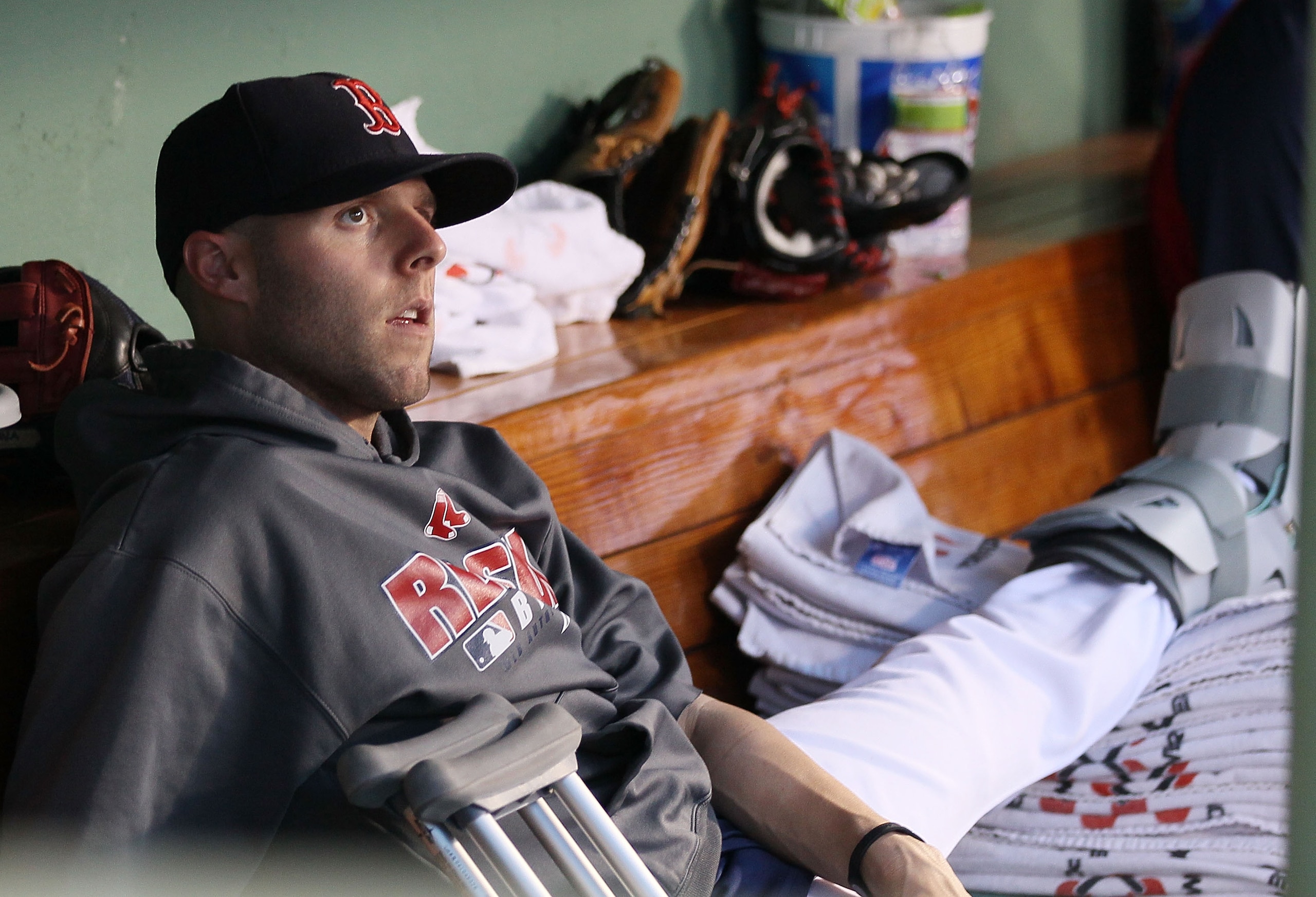 BOSTON - JULY 02:  Dustin Pedroia #15 of the Boston Red Sox sits in the dugout with a broken foot as his teammates take on the Baltimore Orioles on July 2, 2010 at Fenway Park in Boston, Massachusetts.  (Photo by Elsa/Getty Images)