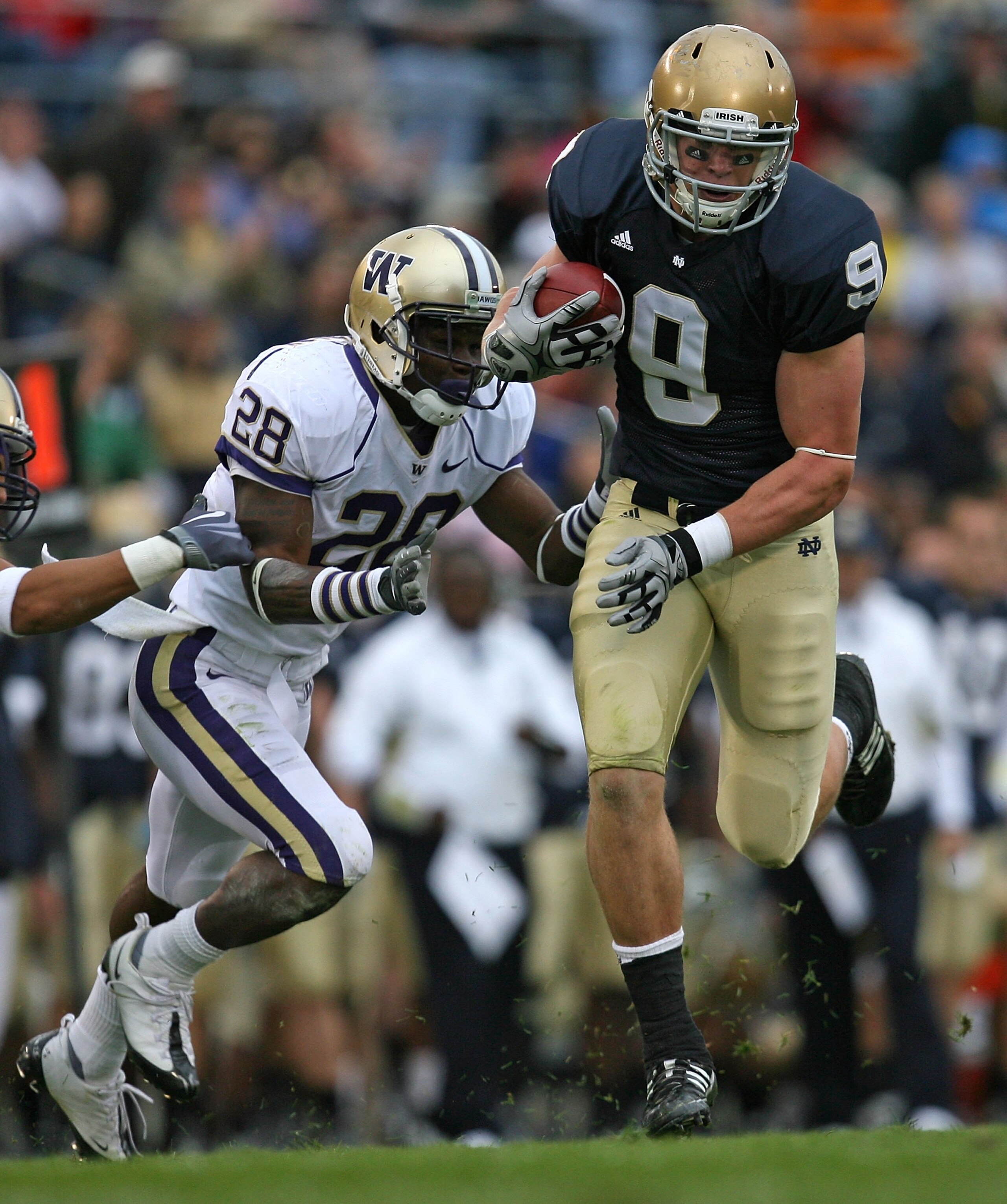 SOUTH BEND, IN - OCTOBER 03: Kyle Rudolph #9 of the Notre Dame Fighting Irish breaks away from Quinton Rochardson #28 of the Washington Huskies after catching the ball on October 3, 2009 at Notre Dame Stadium in South Bend, Indiana. Notre Dame defeated Wa