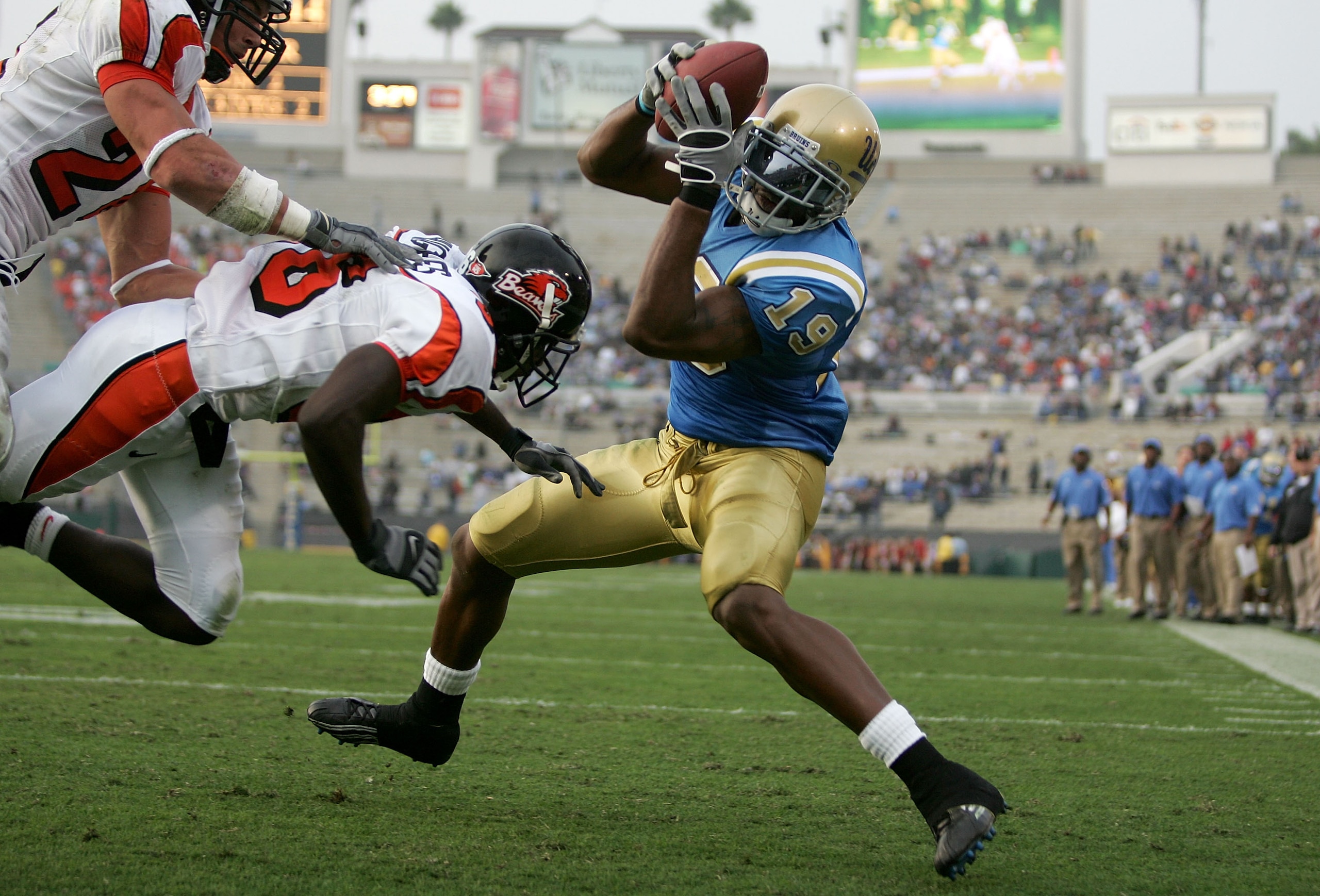 PASADENA, CA - OCTOBER 22:  Marcedes Lewis #19 of the UCLA Bruins catches a touchdown pass over Sabby Piscitelli #24 and Brandon Hughes #36 of the Oregon State Beavers during their game on October 22, 2005 at the Rose Bowl in Pasadena, California.  (Photo