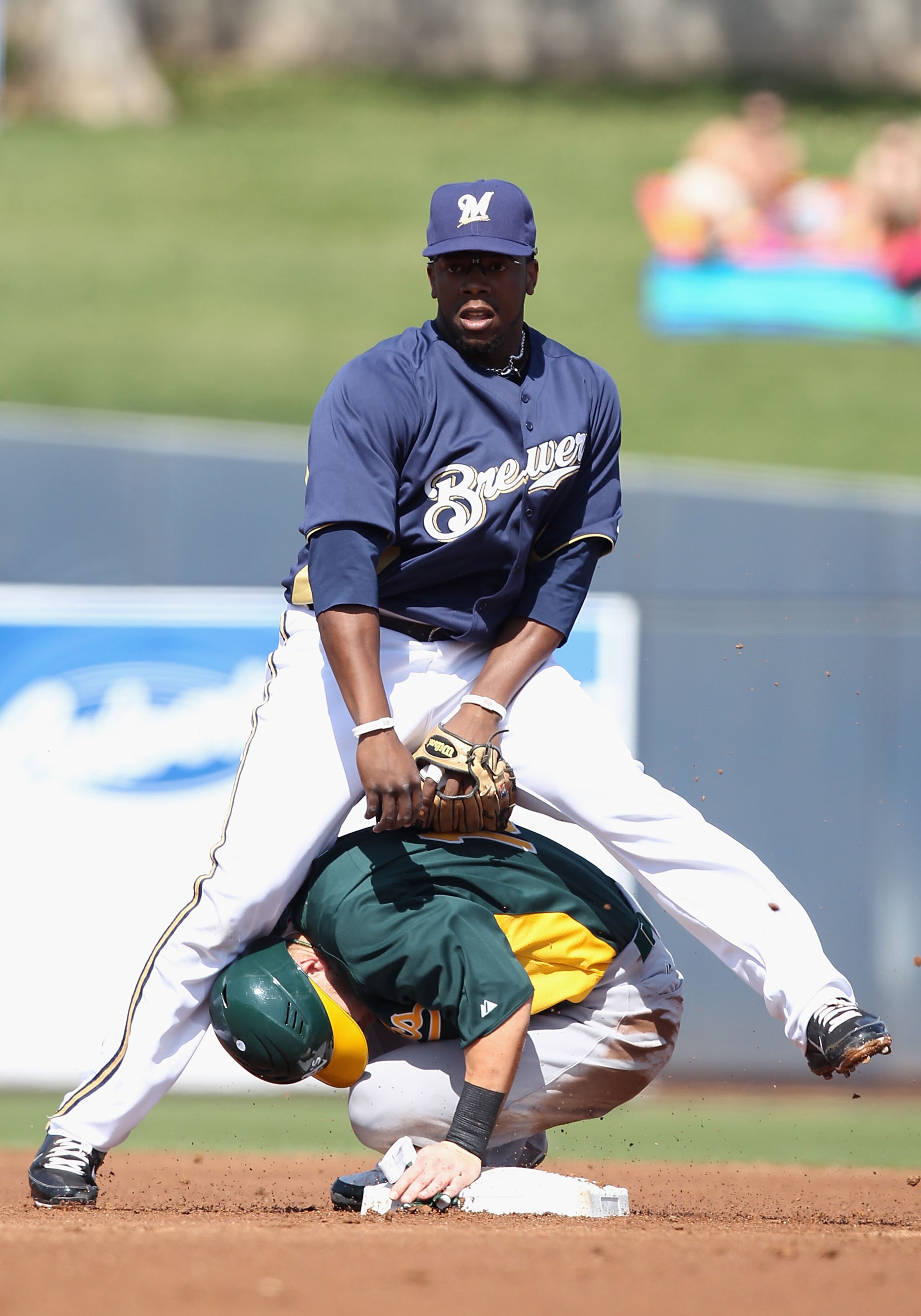 PHOENIX, AZ - MARCH 03:  Infielder Rickie Weeks #23 of the Milwaukee Brewers stands over Daric Barton #10 of the Oakland Athletics after completing a double play during the first inning of the spring training game at Maryvale Baseball Park on March 3, 201