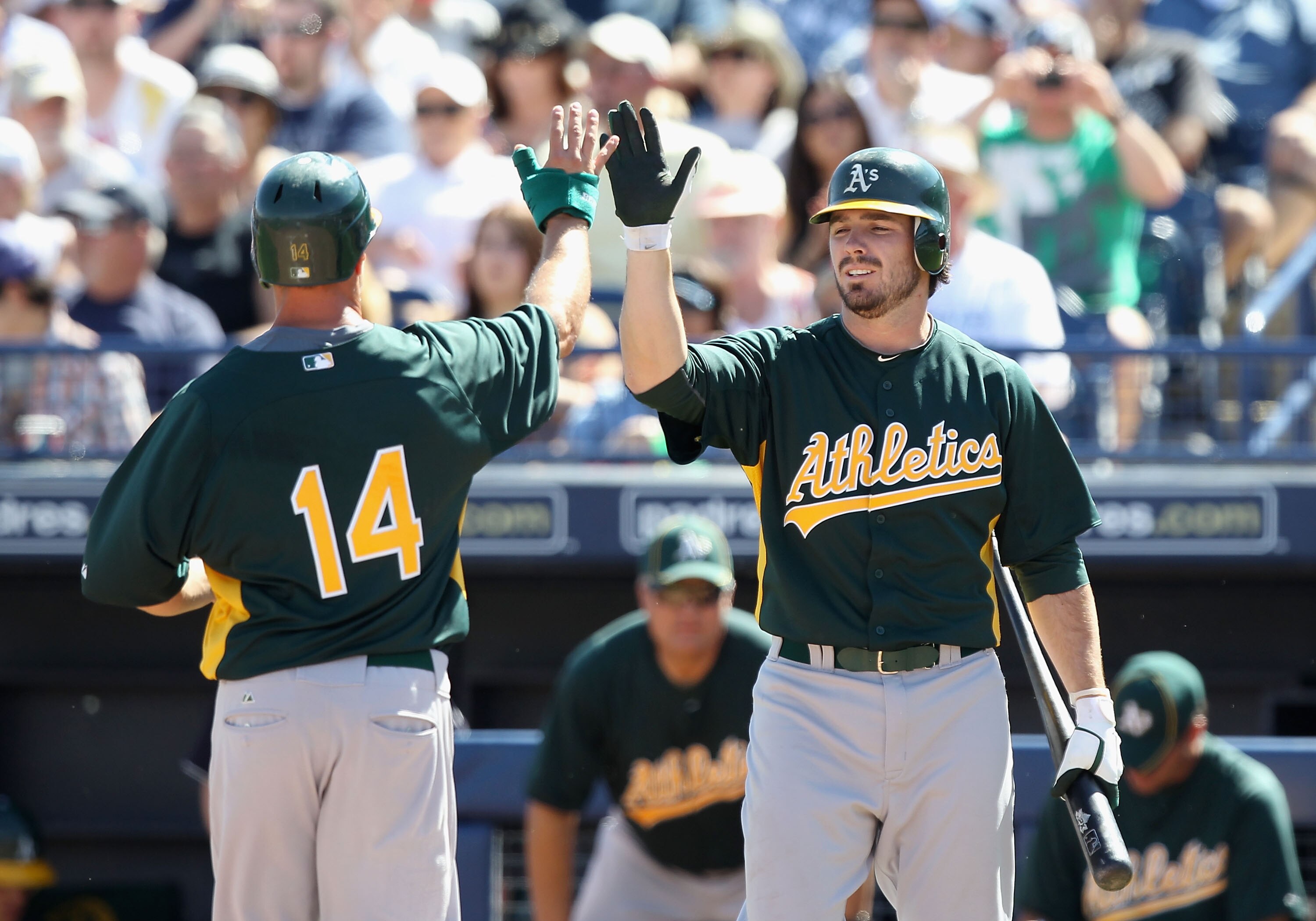 PEORIA, AZ - MARCH 12:  Mark Ellis #14 of the Oakland Athletics high fives teammate Andy LaRoche #21 after Ellis scored a run against the Seattle Mariners during the second inning of the spring training game at Peoria Stadium on March 12, 2011 in Peoria,