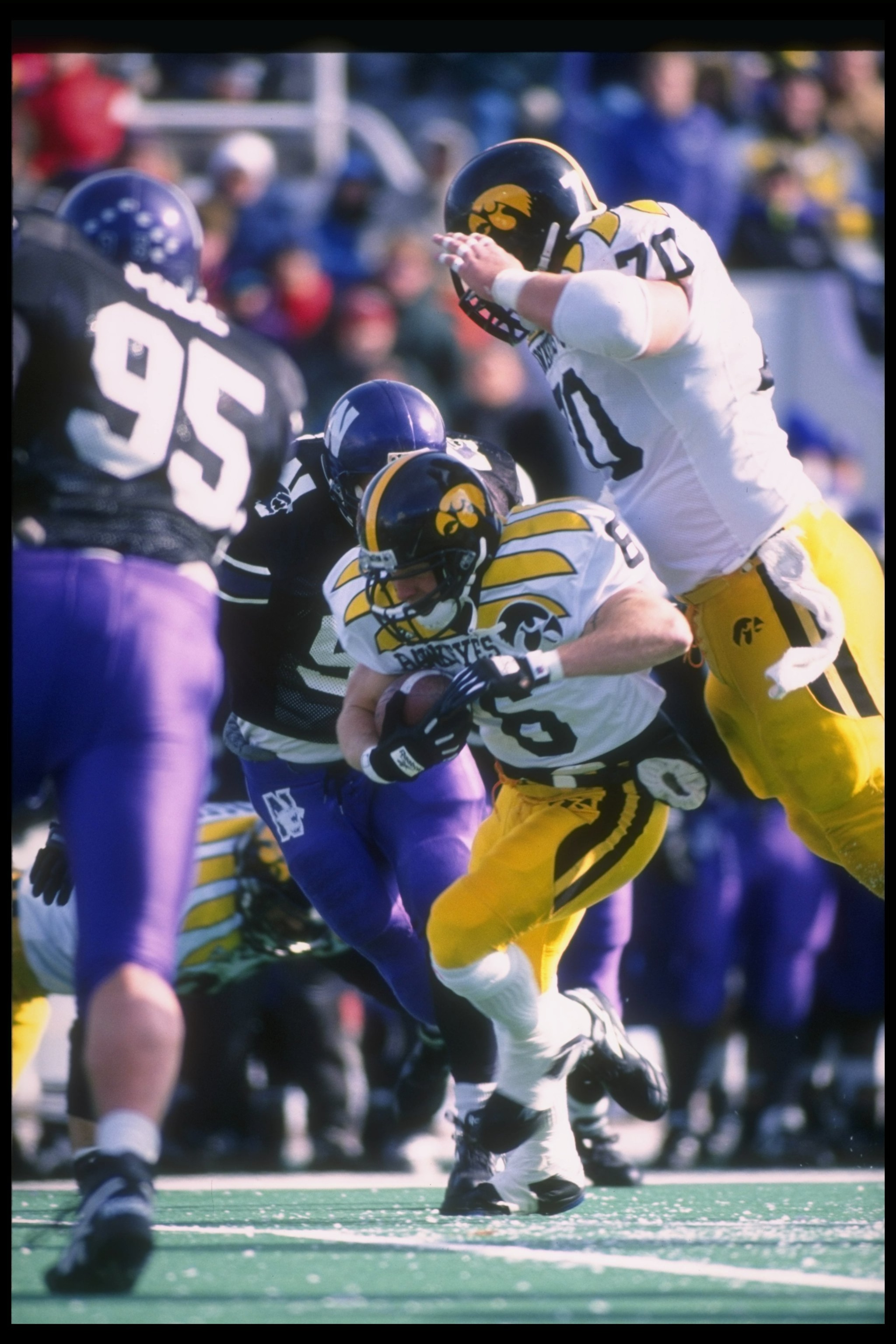 11 Nov 1995:  Center Casey Wiegmann of the Iowa Hawkeyes (right) throws a block as teammate running back Tim Dwight (center) runs with the ball during a game against the Northwestern Wildcats at Dyche Stadium in Evanston, Illinois.  Northwestern won the g