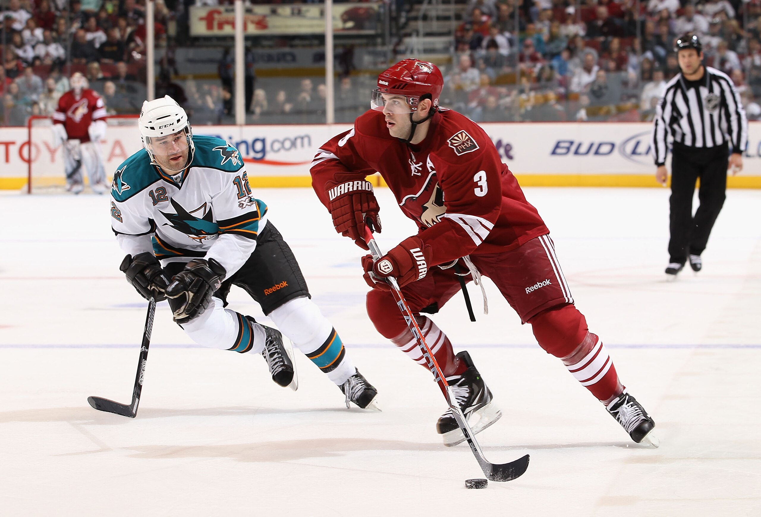 GLENDALE, AZ - MARCH 26:  Keith Yandle #3 of the Phoenix Coyotes skates with the puck past Patrick Marleau #12 of the San Jose Sharks during the second period of the NHL game at Jobing.com Arena on March 26, 2011 in Glendale, Arizona.  (Photo by Christian
