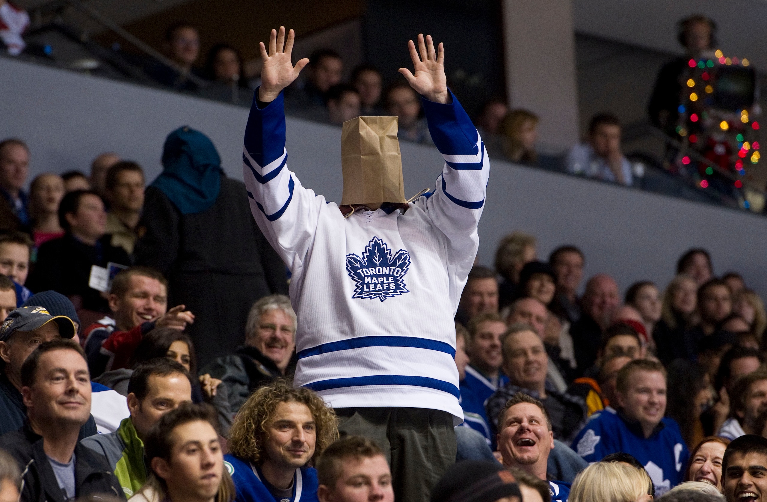 VANCOUVER, CANADA - DECEMBER 18: A Toronto Maple Leafs fans cheers during the late stages of the third period in NHL action on December 18, 2010 between the Vancouver Canucks and the Maple Leafs at Rogers Arena in Vancouver, BC, Canada.  (Photo by Rich La