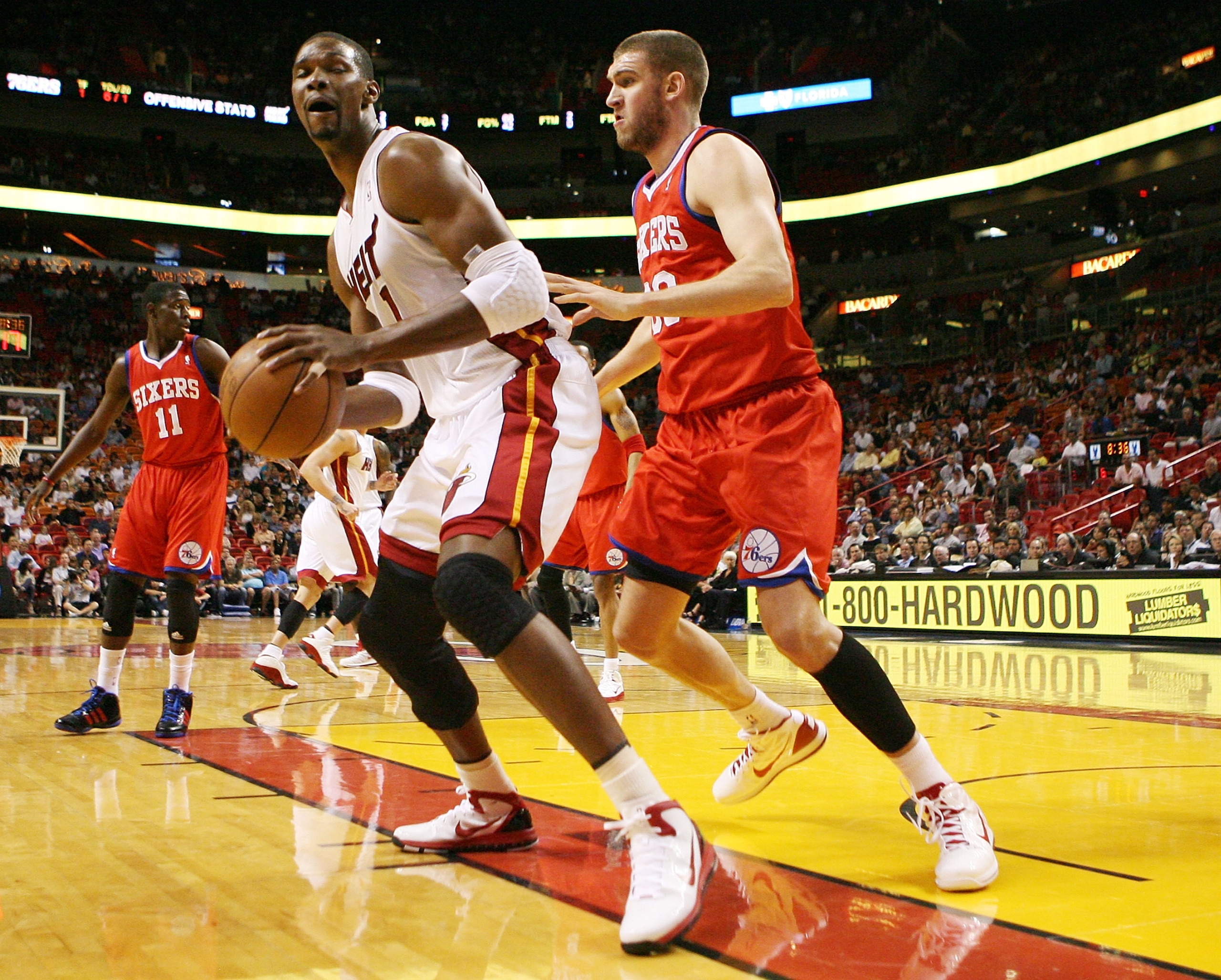 MIAMI, FL - MARCH 25: Forward Chris Bosh #1 of the Miami Heat is defended by Center Spencer hawes #00 of the Philadelphia Sixers at American Airlines Arena on March 25, 2011 in Miami, Florida. NOTE TO USER: User expressly acknowledges and agrees that, by