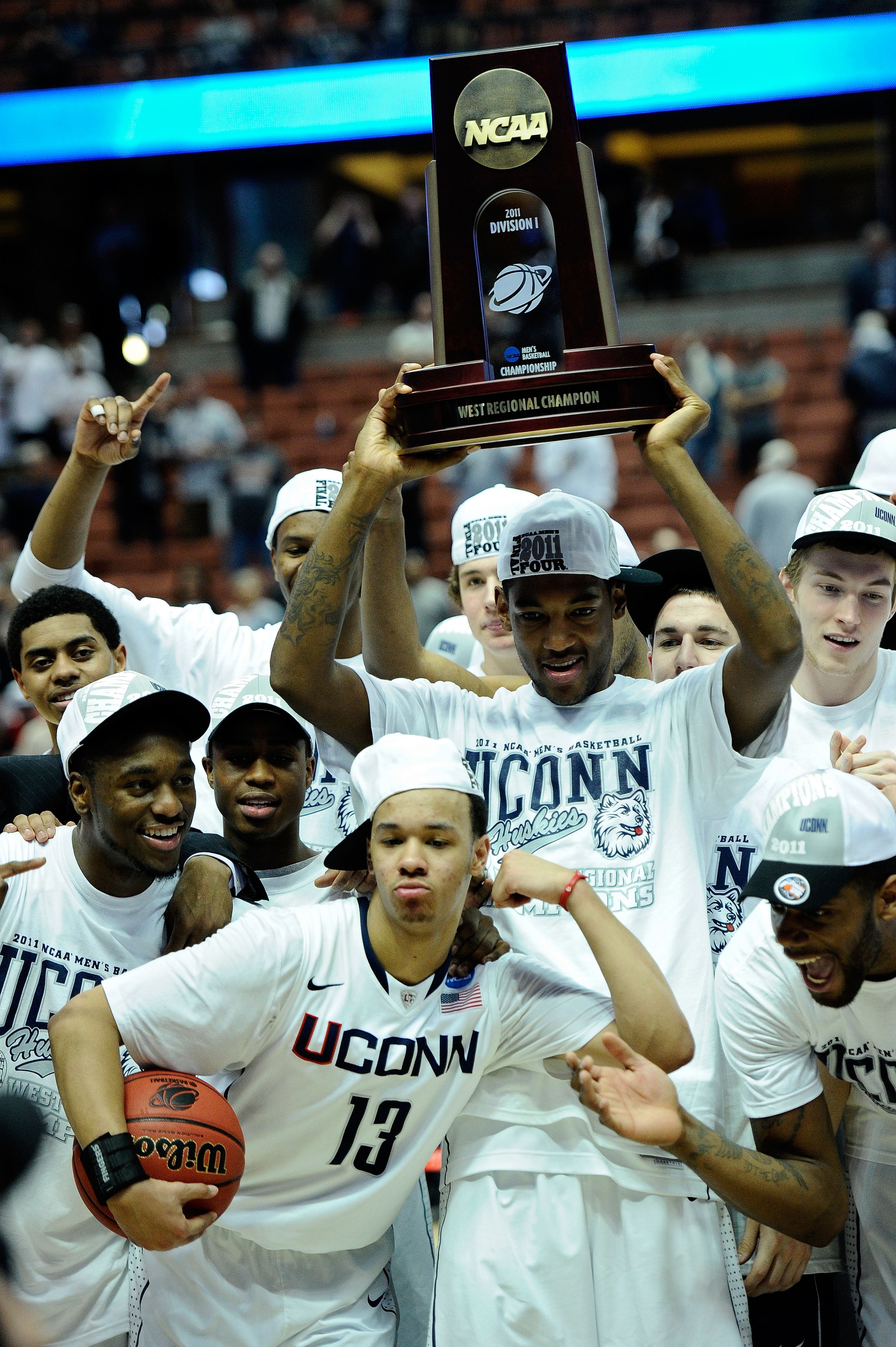 ANAHEIM, CA - MARCH 26:  Shabazz Napier #13, Roscoe Smith #22 Kemba Walker #15 and the Connecticut Huskies celebrates with the trophy after defeating the Arizona Wildcats during the west regional final of the 2011 NCAA men's basketball tournament at the H