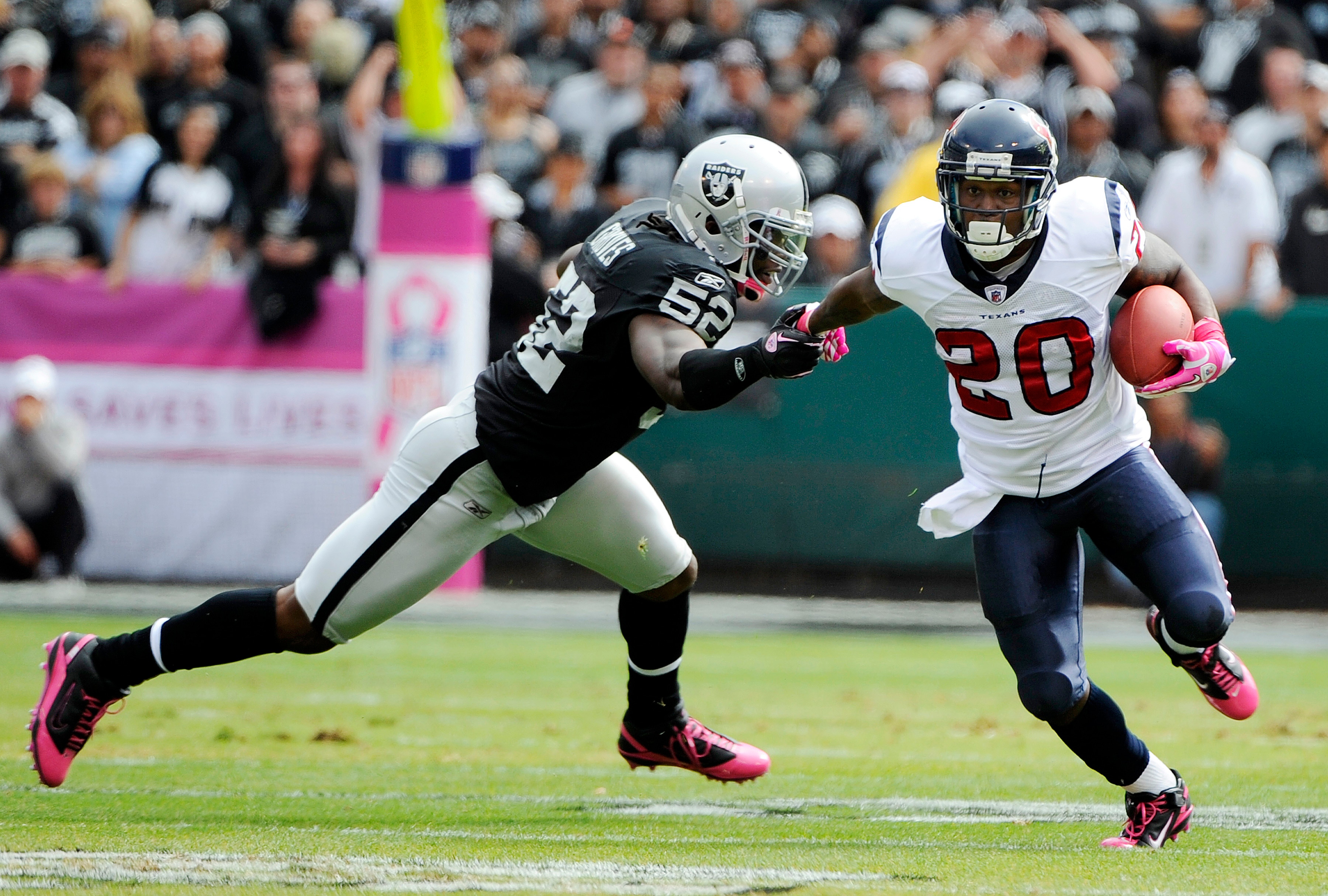 OAKLAND, CA - OCTOBER 3: Running back Steve Slaton #20 of the Houston Texans pushes away from linebacker Quentin Groves #52 of the Oakland Raiders during an NFL football game October 3, 2010 at The Oakland-Alameda County Coliseum in Oakland, California. OAKLAND, CA - OCTOBER 3: Running back Steve Slaton #20 of the Houston Texans pushes away from linebacker Quentin Groves #52 of the Oakland Raiders during an NFL football game October 3, 2010 at The Oakland-Alameda County Coliseum in Oakland, California.