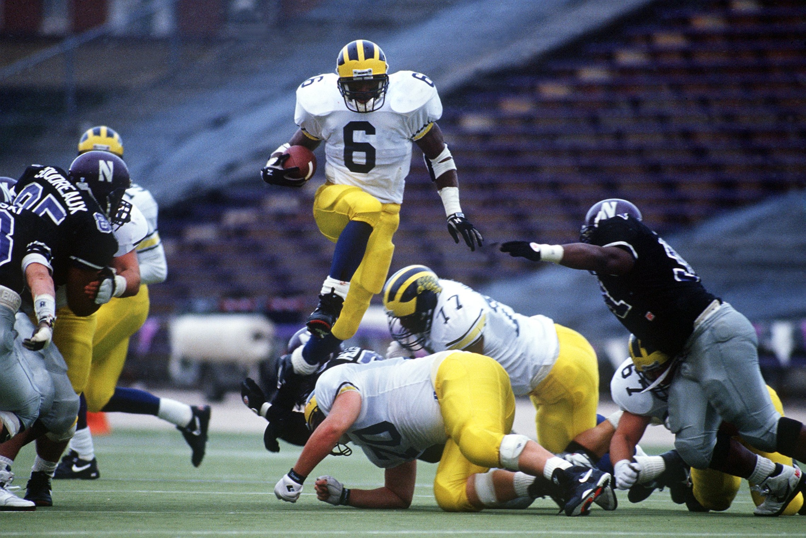 7 Nov 1992: MICHIGAN RUNNING TYRONE WHEATLEY BACK LEAPS OVER THE LINE OF SCRIMMAGE DURING THE WOLVERINES GAME AT THE NORTHWESTERN WILCATS IN EVANSTON, ILLINOIS.