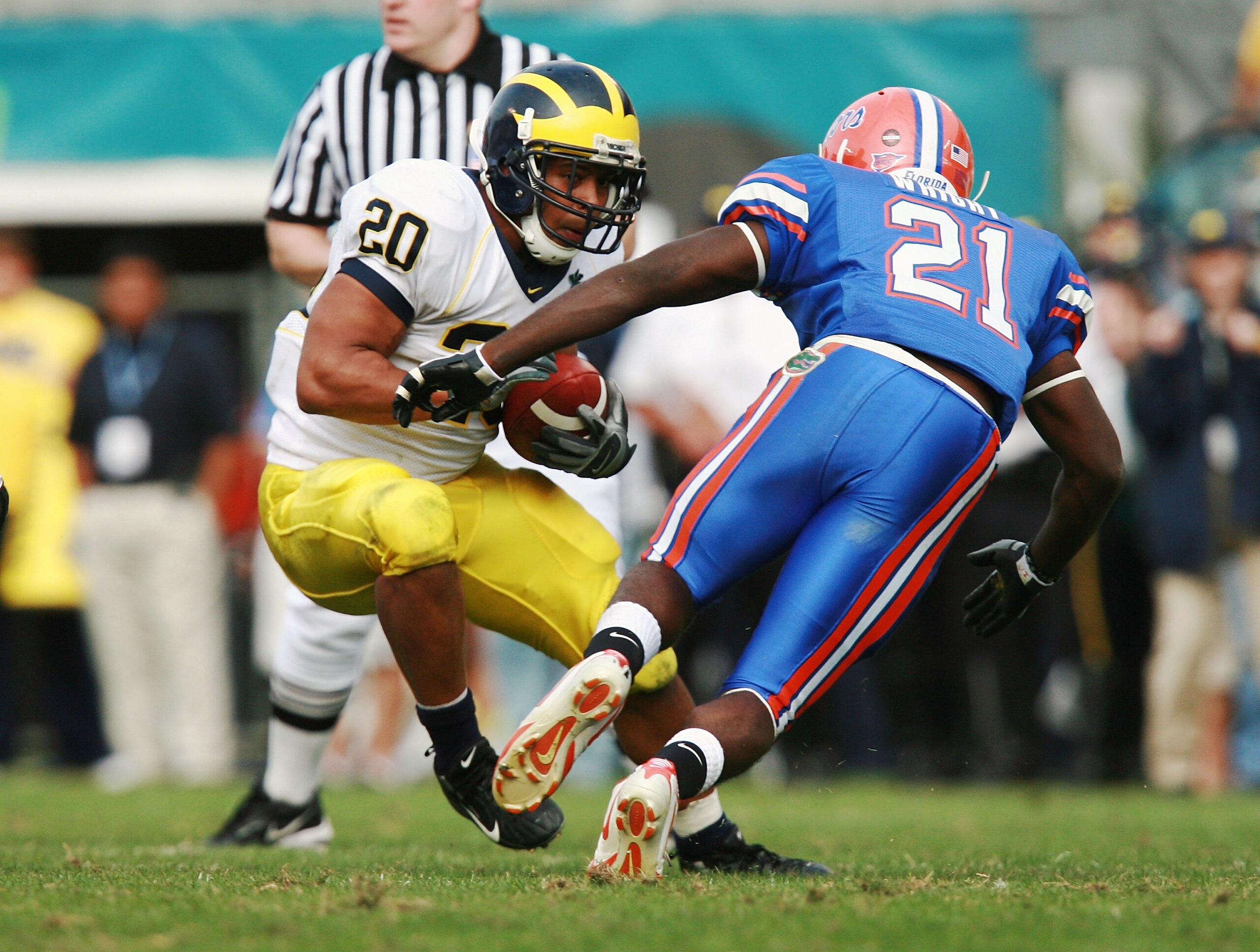 ORLANDO, FL - JANUARY 01:  Running back Mike Hart #20 of the Michigan Wolverines tries to avoid a tackle attempt by safety Major Wright #21of  the Florida Gators in the Capital One Bowl at Florida Citrus Bowl on January 1, 2008 in Orlando, Florida. Michig