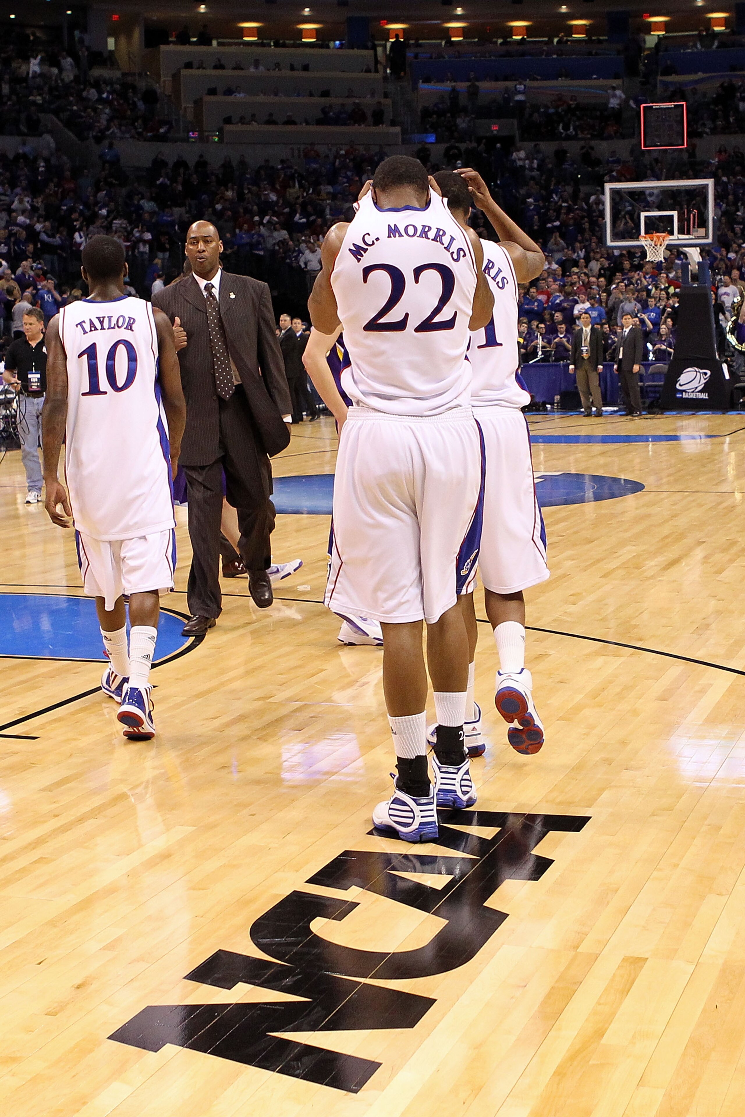 OKLAHOMA CITY - MARCH 20:  Assistant coach Danny Manning of the Kansas Jayhawks consoles Tyshawn Taylor #10, Marcus Morris #22 and Markieff Morris #21 after they lost 69-67 against the Northern Iowa Panthers during the second round of the 2010 NCAA men's