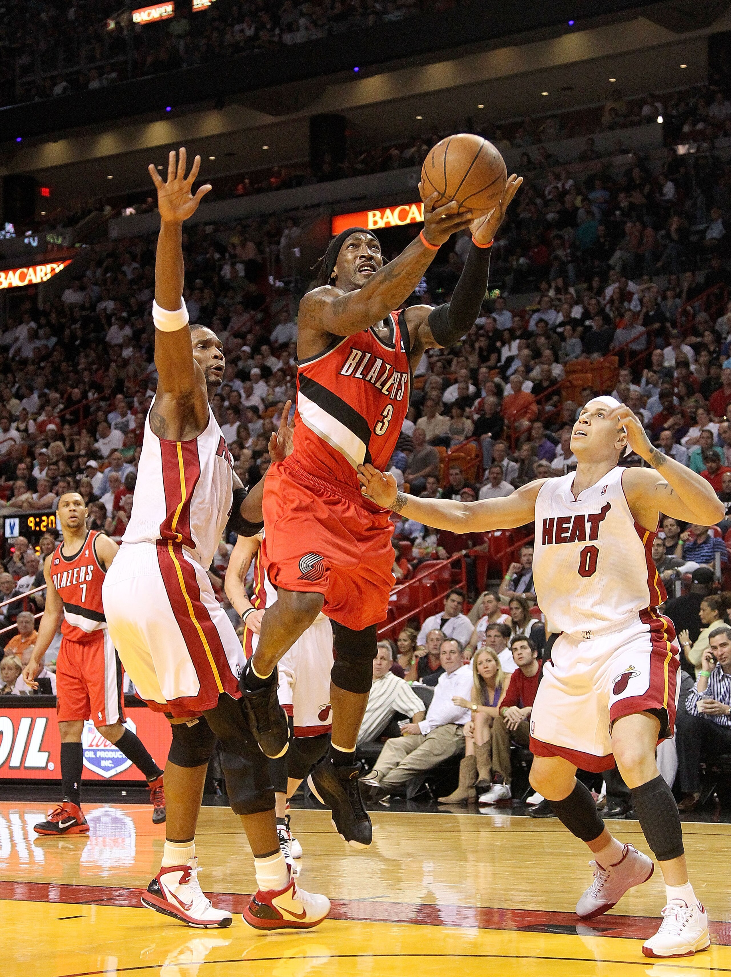 MIAMI, FL - MARCH 08: Gerald Wallace #3 of the Portland Trail Blazers splits through Chris Bosh #1 and Mike Bibby #0 of the Miami Heat during a game at American Airlines Arena on March 8, 2011 in Miami, Florida. NOTE TO USER: User expressly acknowledges a