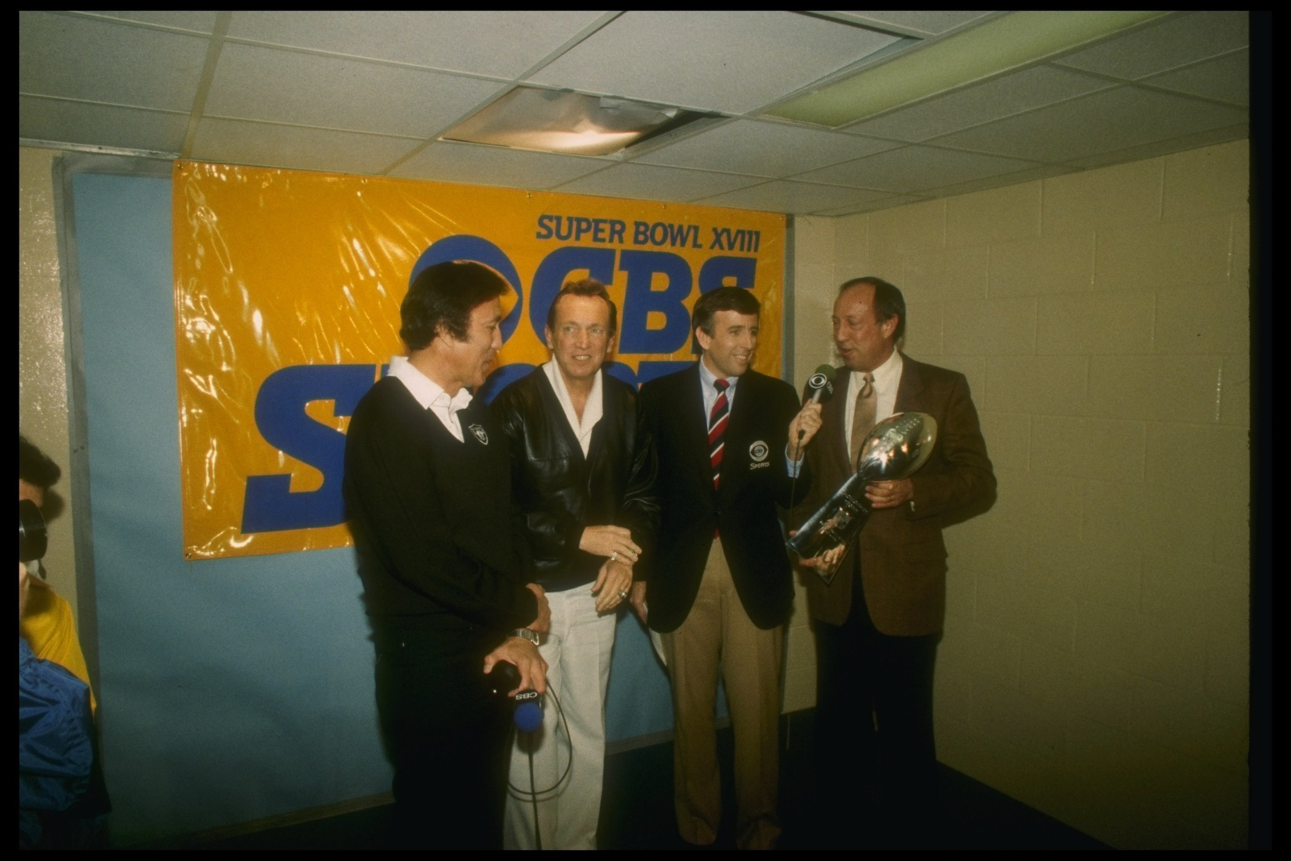 22 Jan 1984: Los Angeles Raiders head coach Tom Flores, Raiders owner Al Davis, Brent Musberger, and NFL Commissioner Pete Rozelle (l to r) at the presentation of the Lombardi Trophy after Super Bowl XVIII between the Los Angeles Raiders and the Washingto