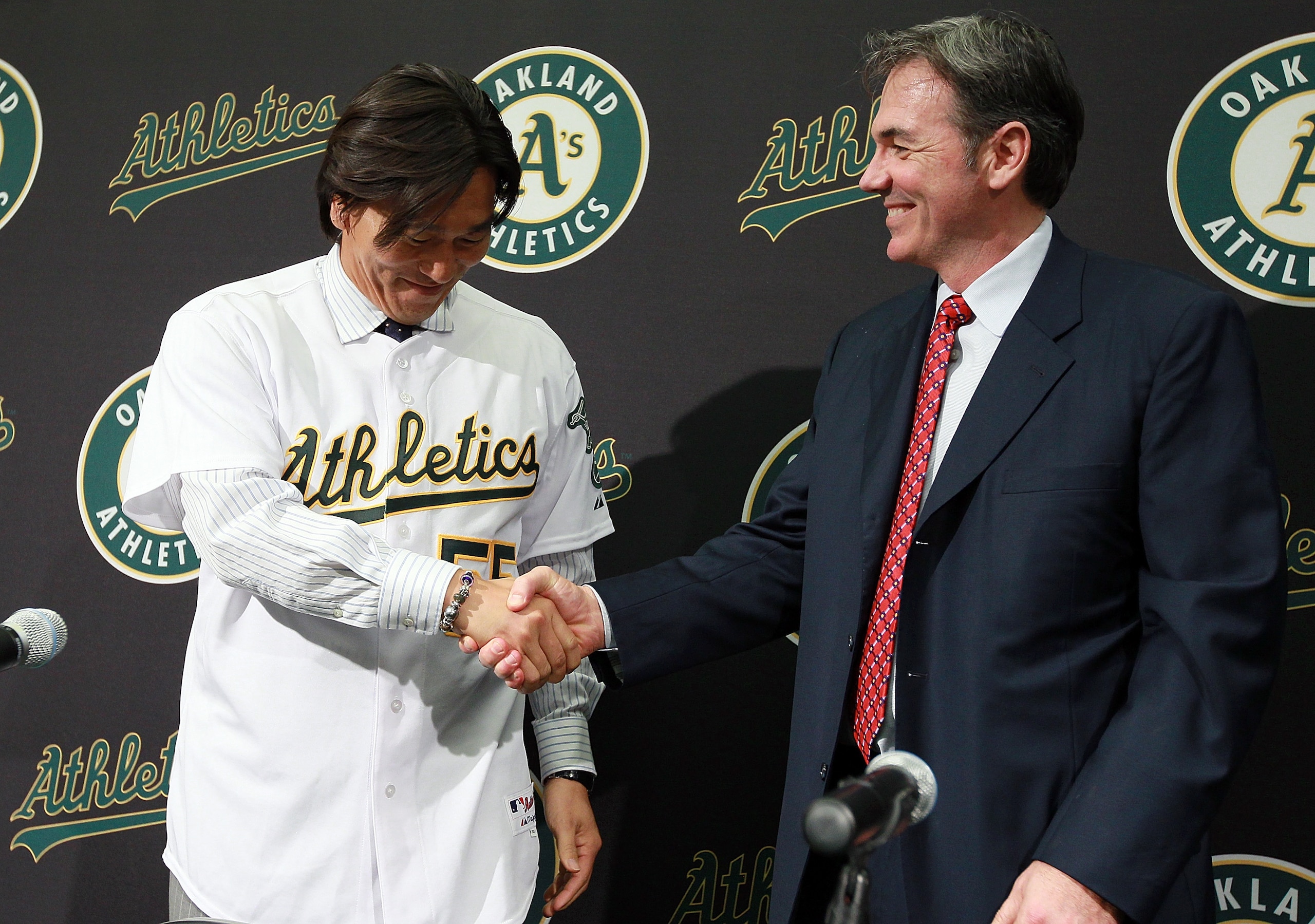 OAKLAND, CA - DECEMBER 14:  Hideki Matsui (L) shakes hands with Oakland Athletics general manager Billy Beane (R) after trying on his new jersey during a press conference where he was introduced as the newest member of the Oakland Athletics at Oakland-Ala